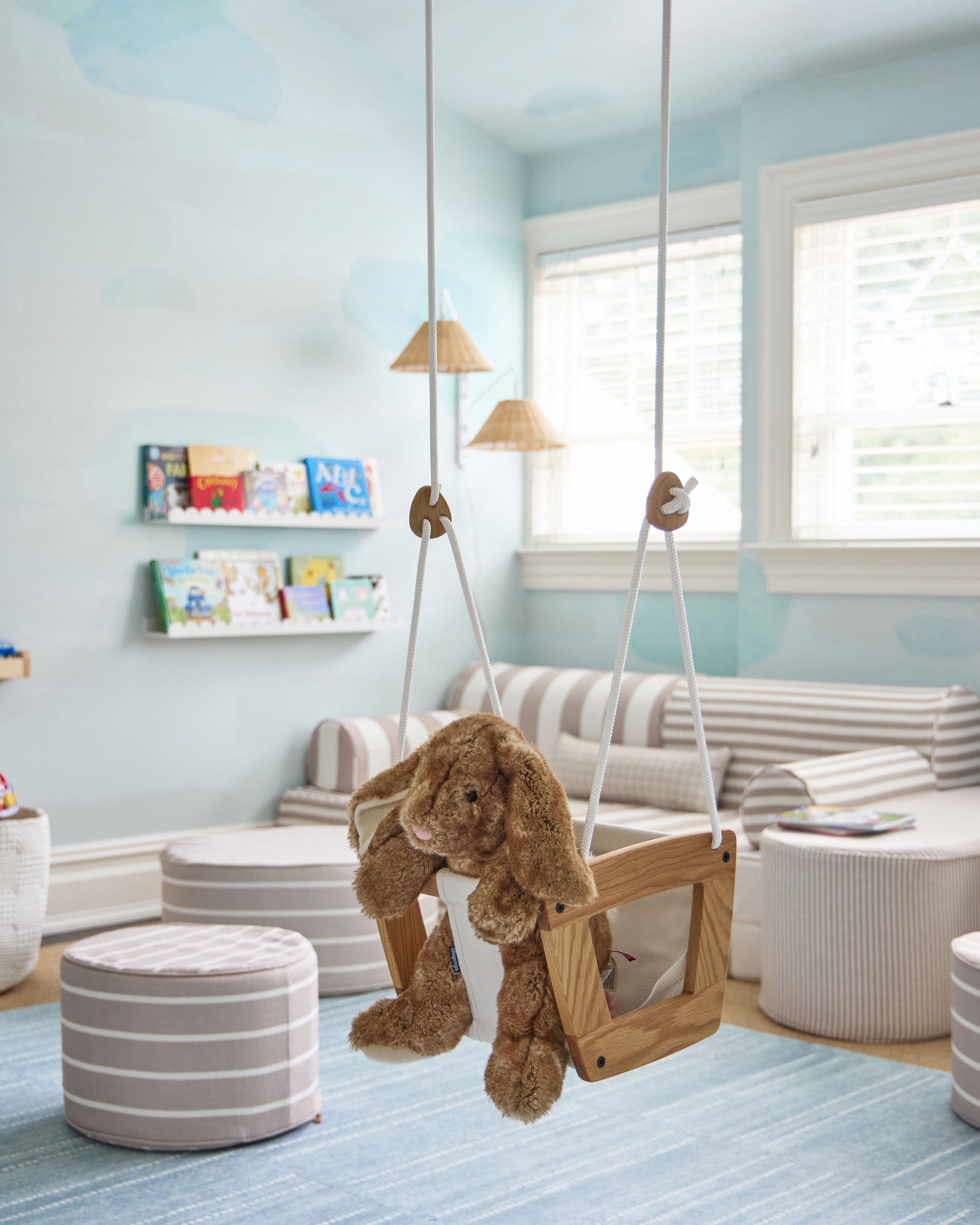 Brown bunny in baby swing with cozy reading area in background 