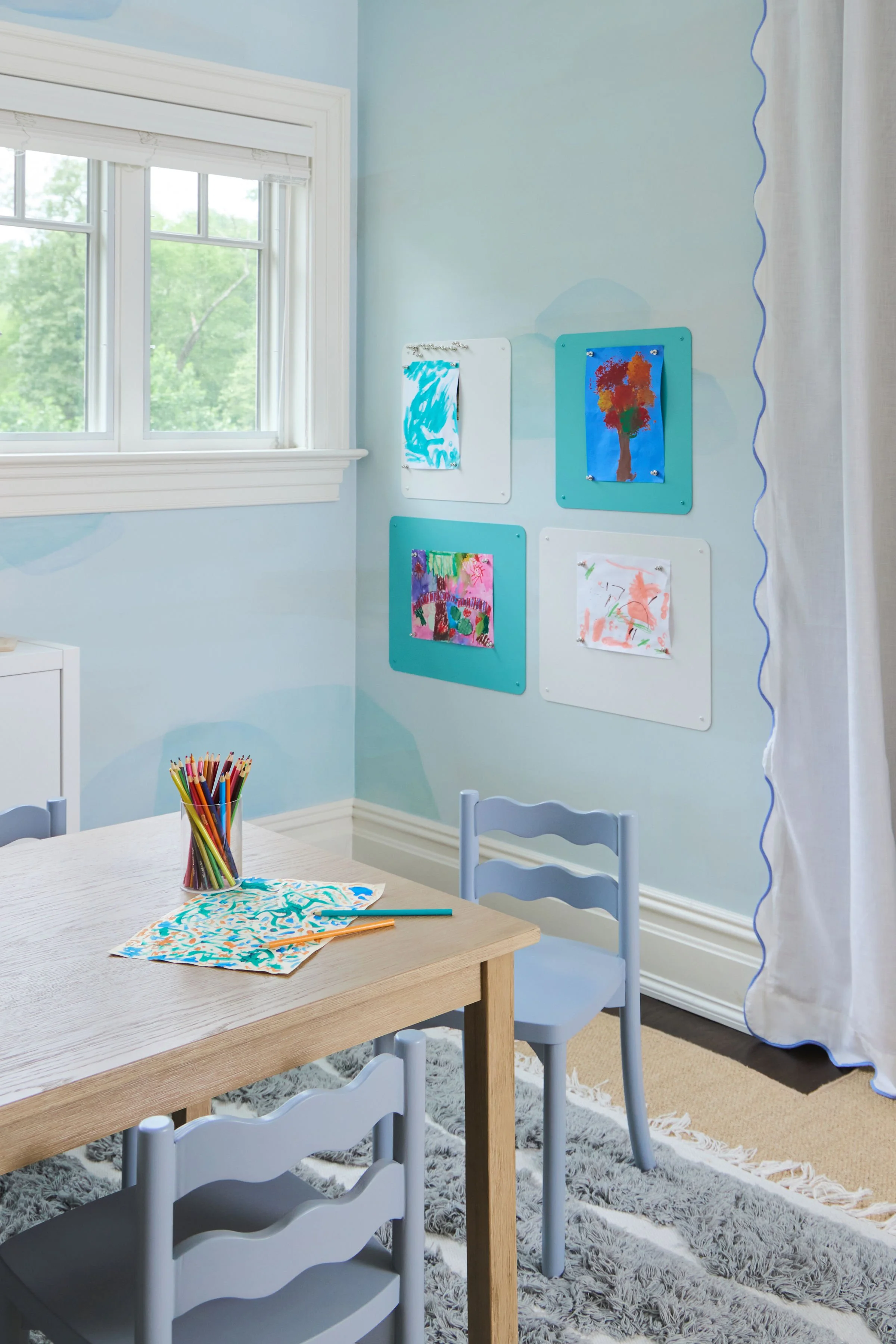 Kids arts and crafts table and chairs with kids' art gallery in background