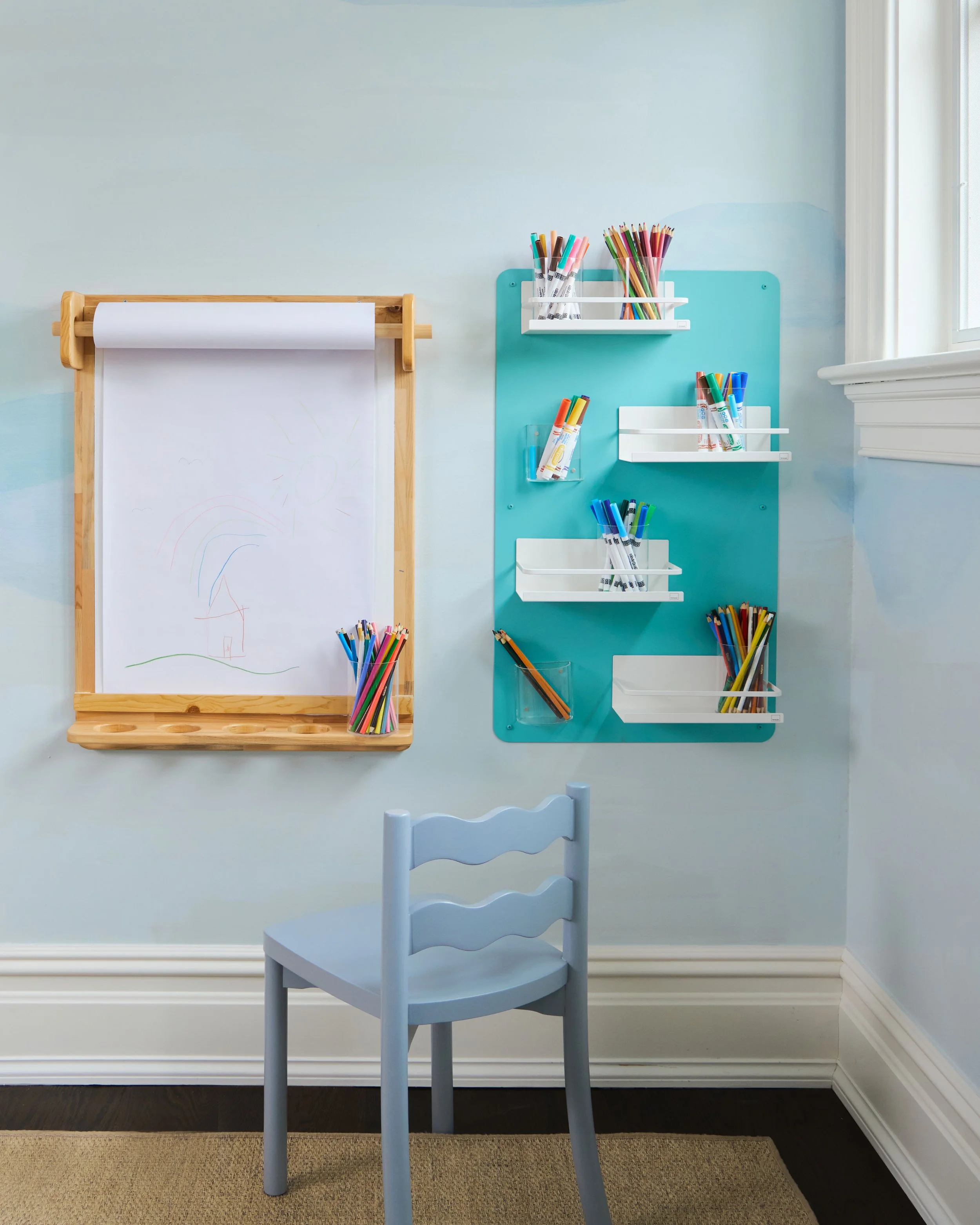 wall mounted paper roll and magnetic art supply board with colorful art supplies 