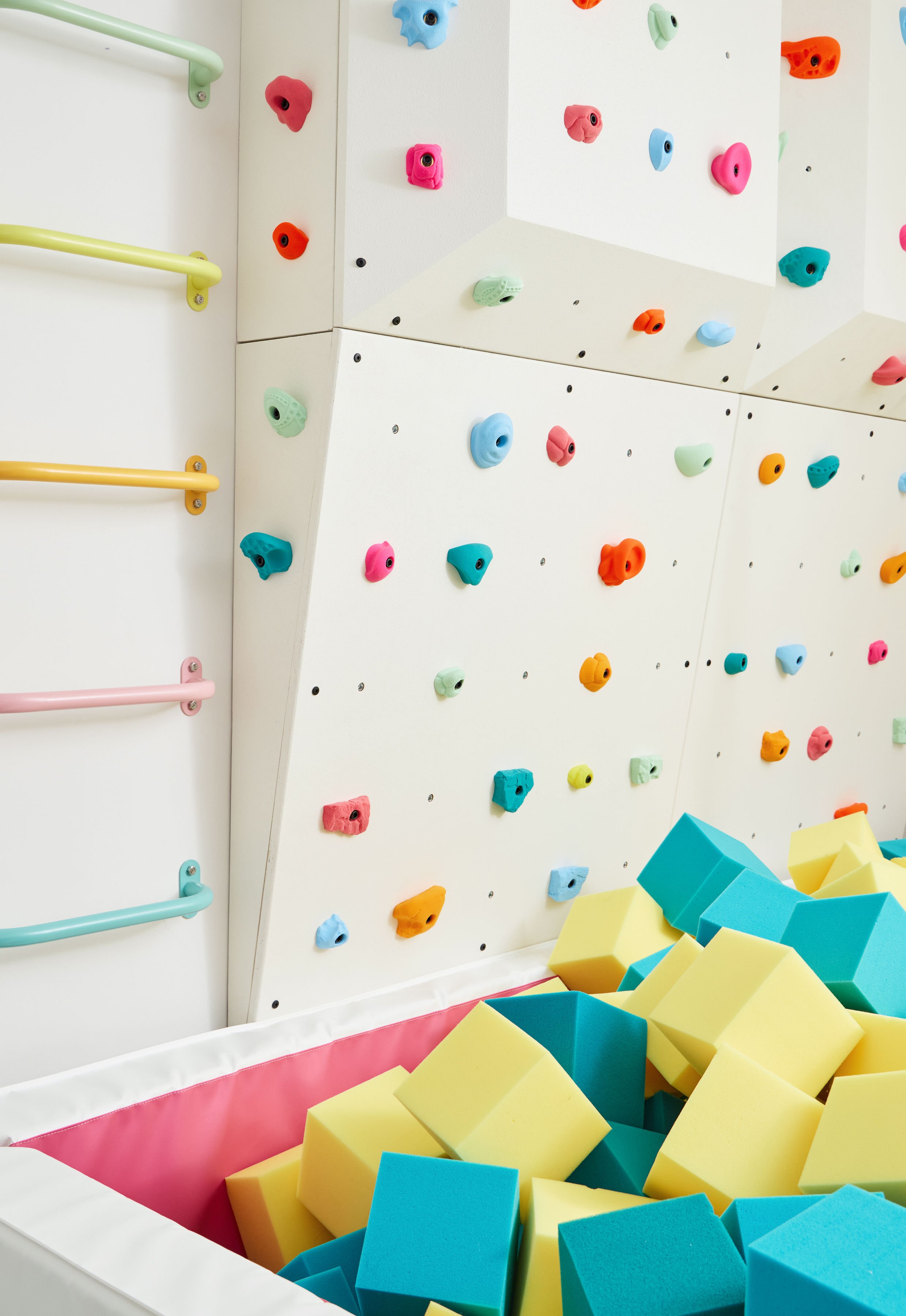 Colorful kids' 3D climbing wall above a foam pit filled with foam cubes