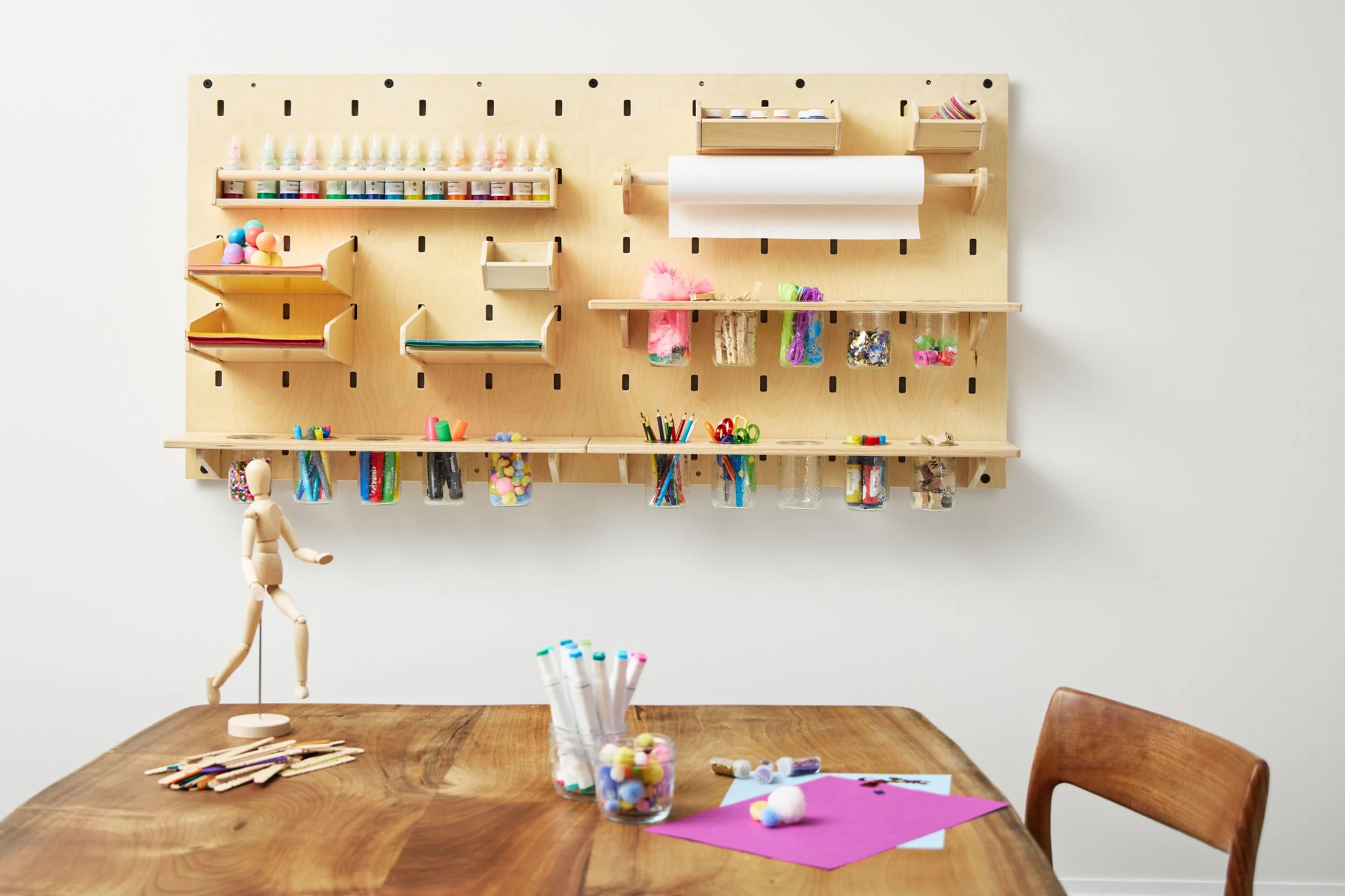 Kids' art space with wall-mounted pegboard storage for arts and crafts supplies