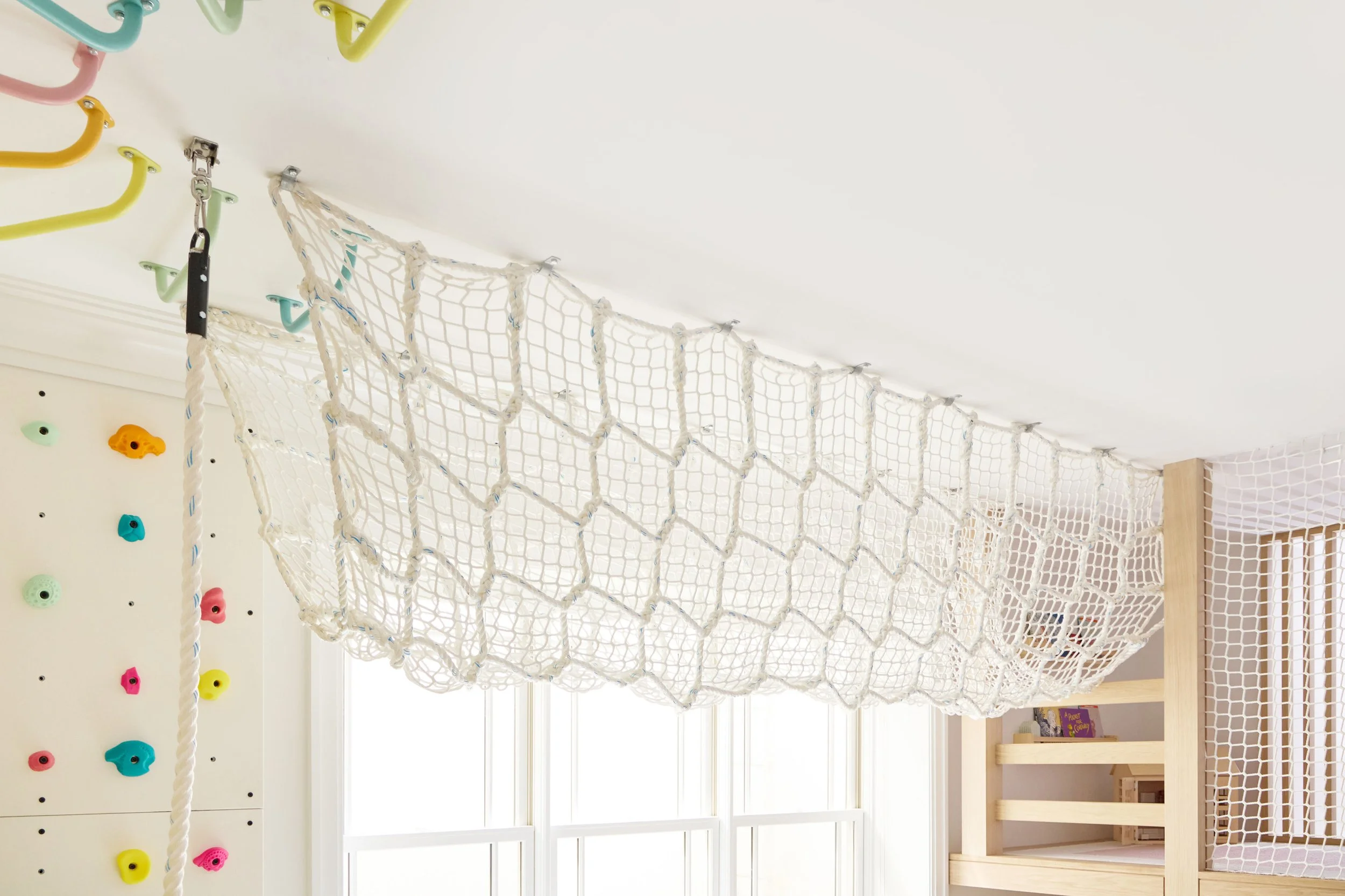 Indoor cargo net tunnel suspended from the ceiling of a kids' playroom
