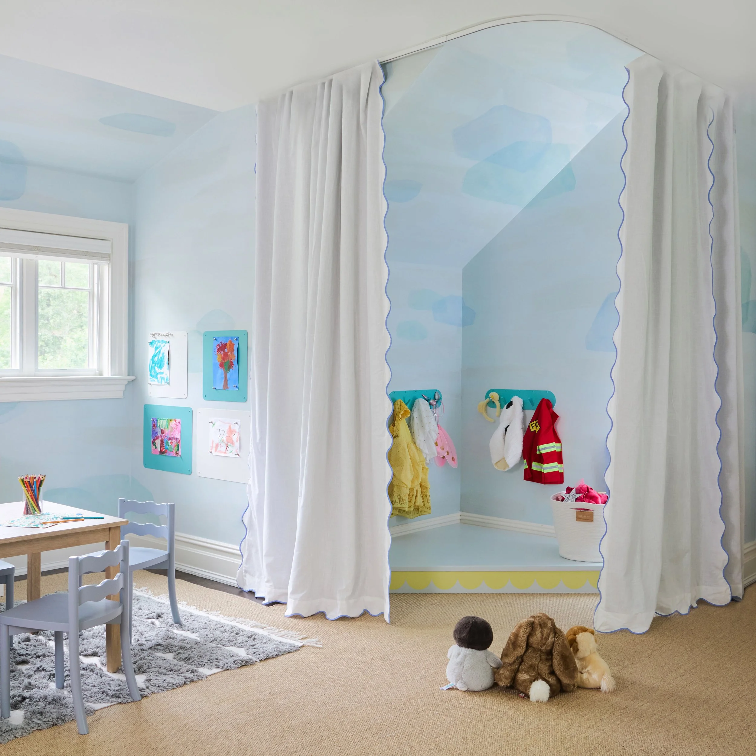 Kids' stage in corner of playroom with scalloped stage curtains