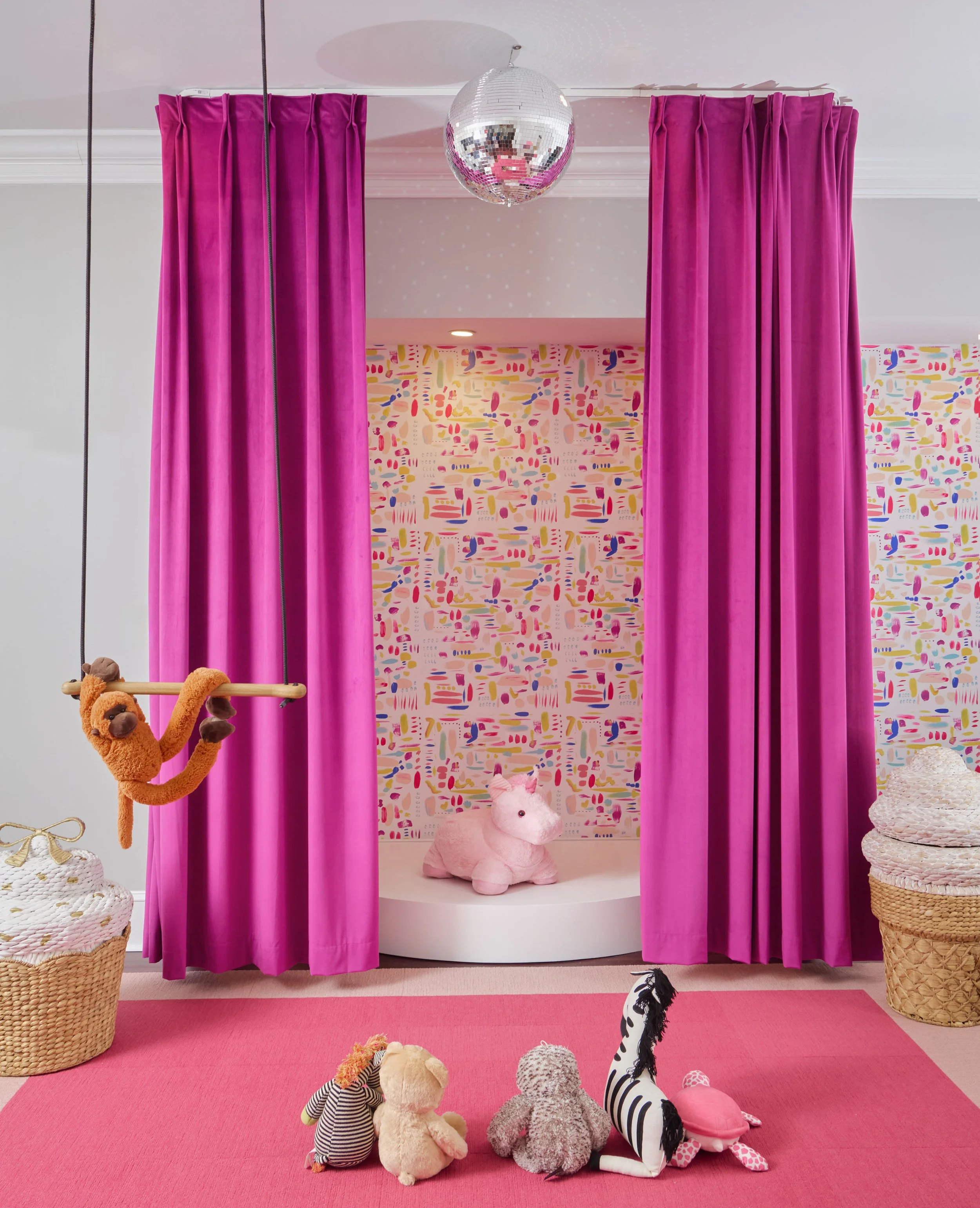 Stage in kids' playroom with colorful wallpaper, a toy monkey on a trapeze and a unicorn on the stage