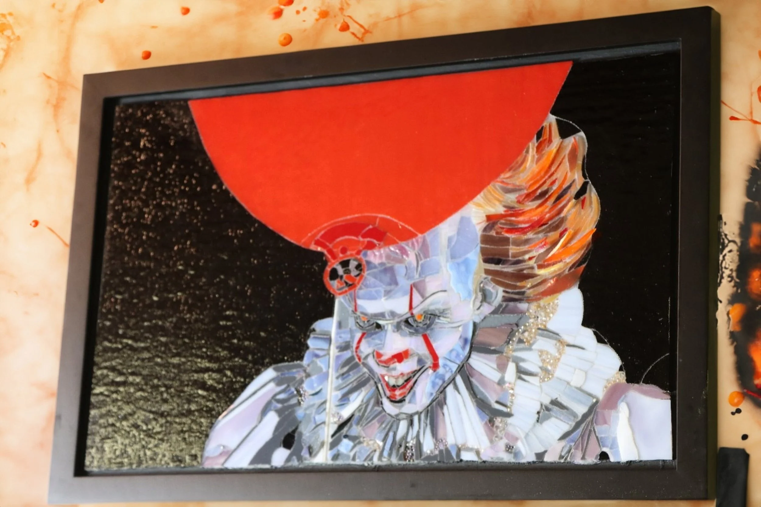 A mosaic artwork of Pennywise the clown from Stephen King's 'It', with a red balloon in the background.