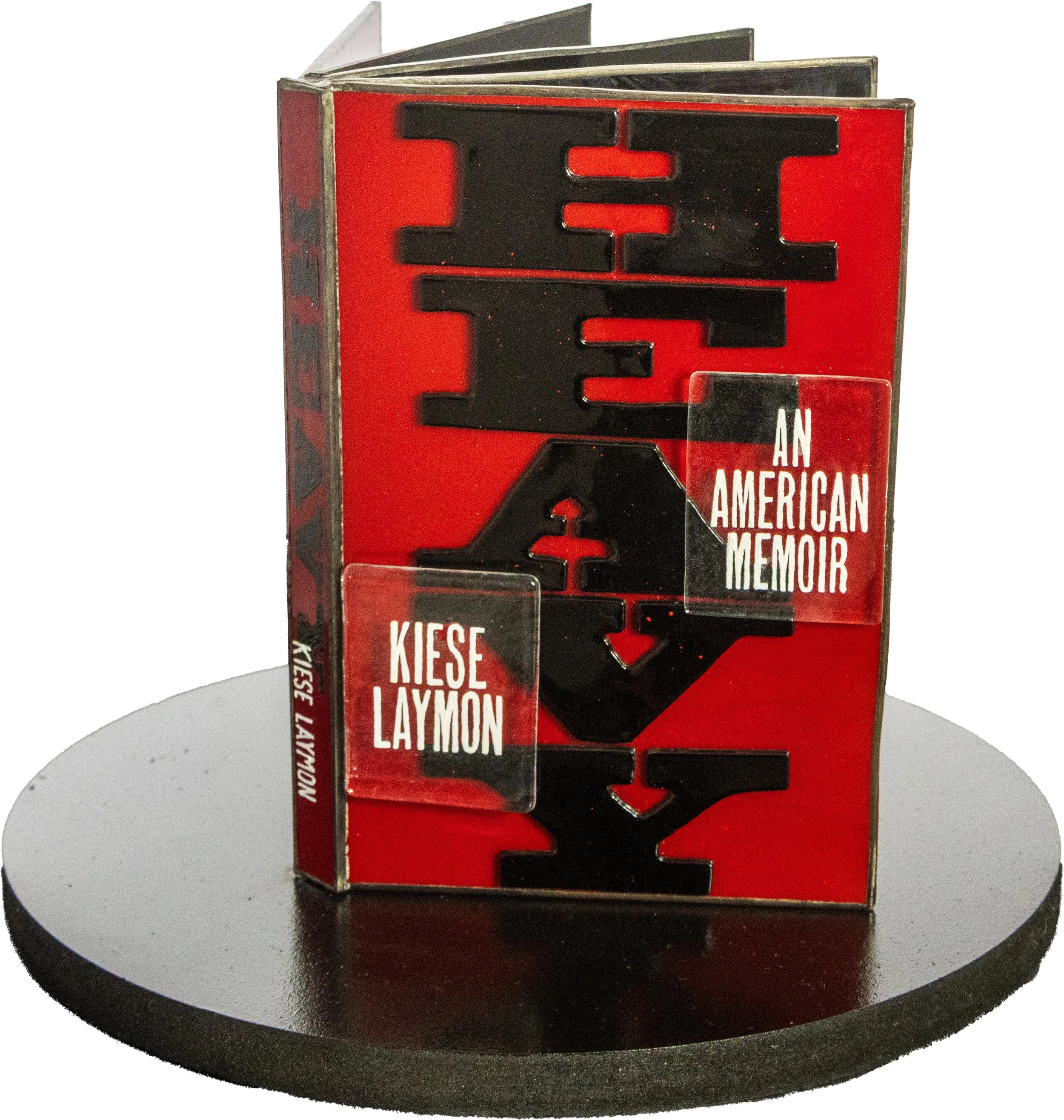 Book titled 'Hate: An American Memoir' by Kiese Laymon displayed standing upright on a black circular platform.