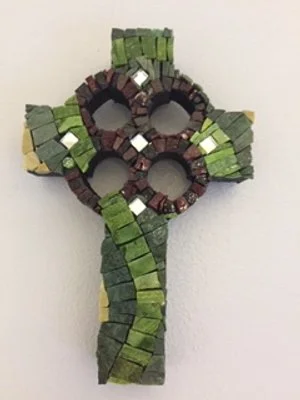 Mosaic cross featuring three snake heads made of small, colored tiles in green, yellow, and purple.