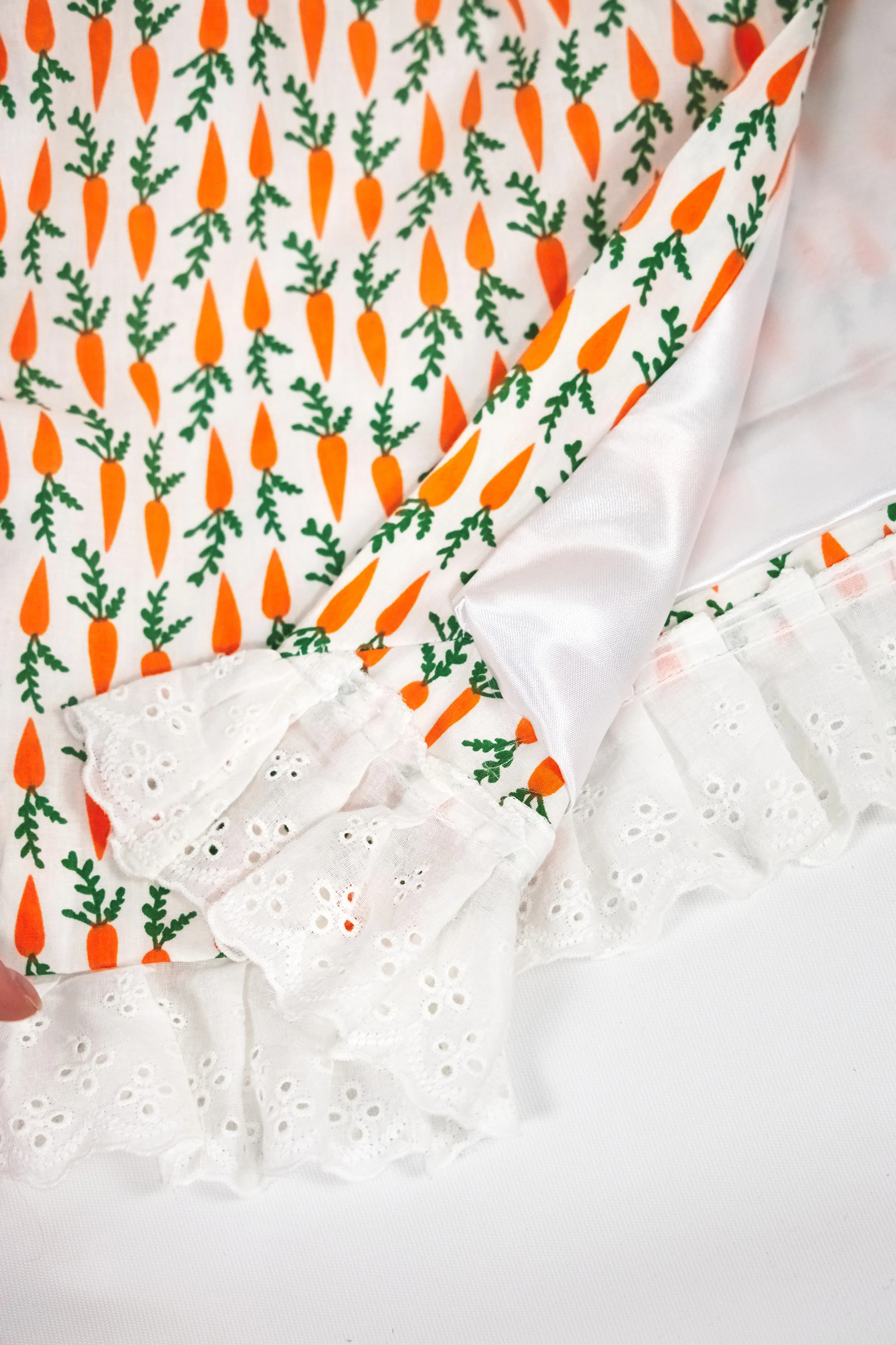 Close-up of white broderie anglaise lace trim on cream carrot print cotton skirt — Carrot Cake by B.Brand