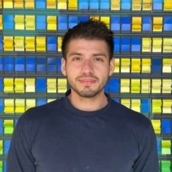 Man standing in front of colorful mosaic wall
