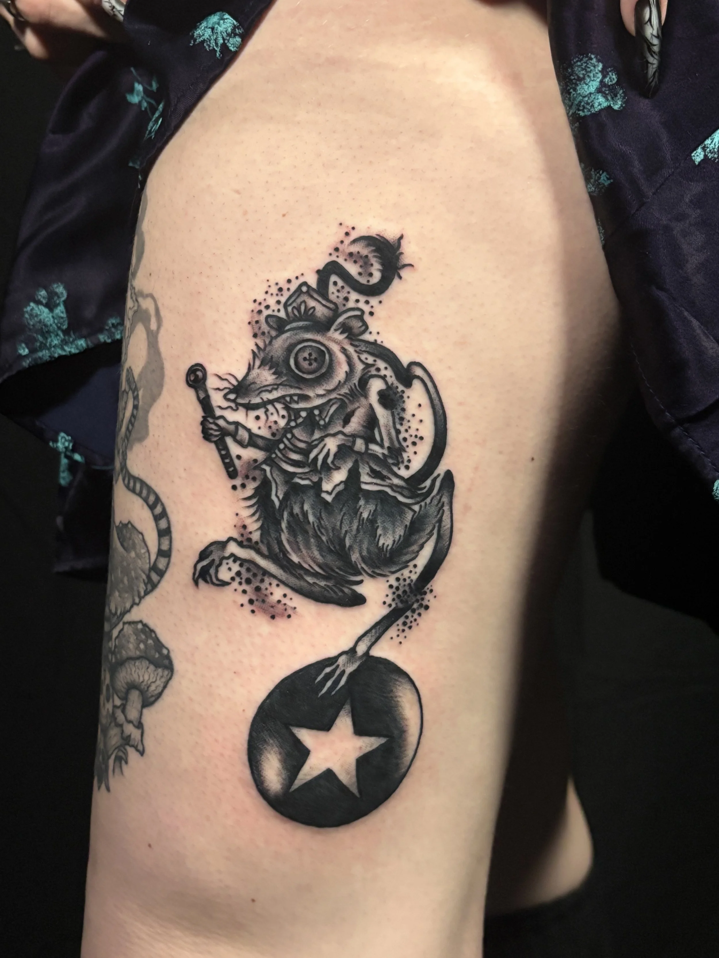 Tattoo of a butterfly with wings resembling an owl's eyes, surrounded by black claw marks on a person's arm.