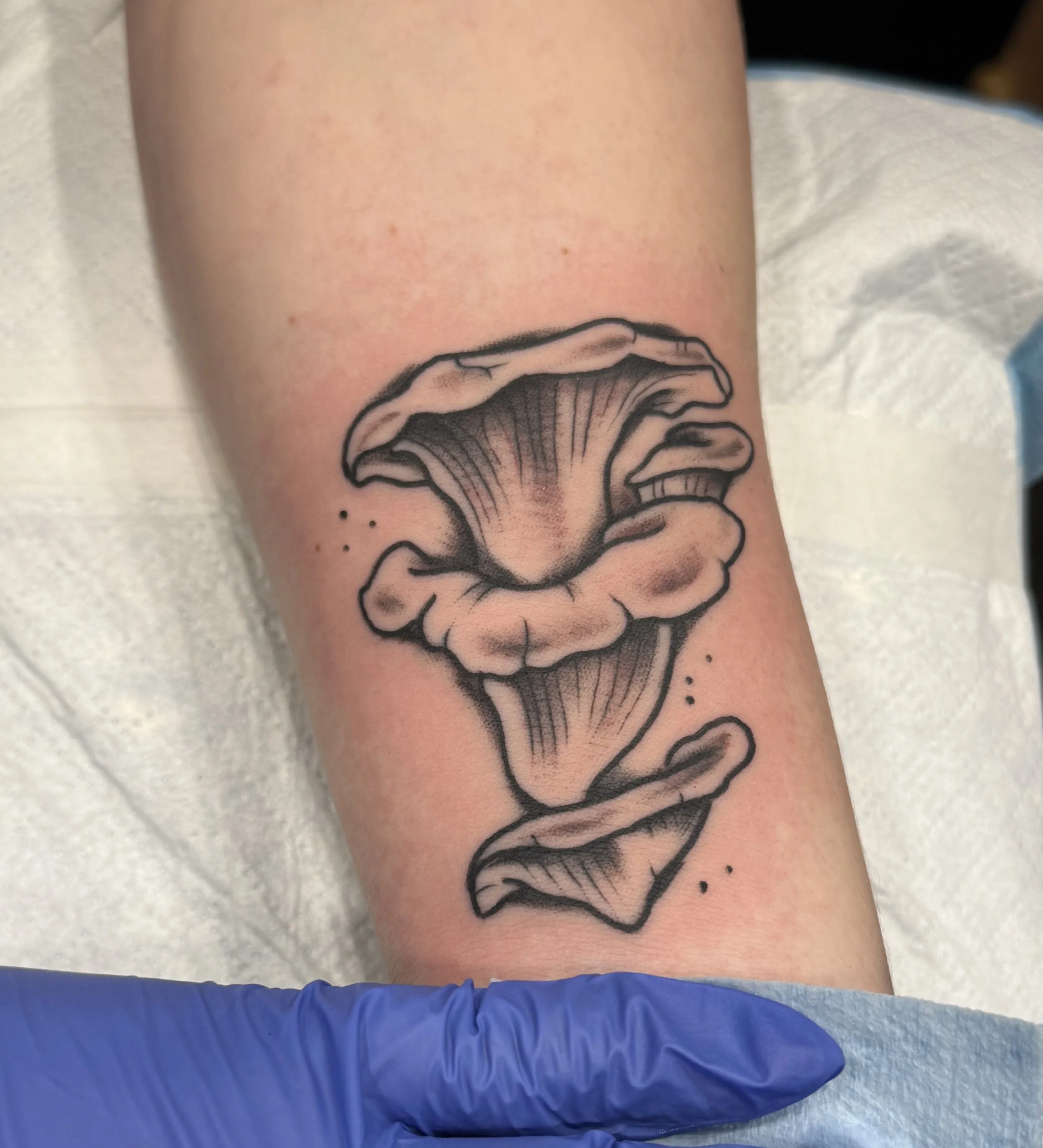 Black tattoo of an ornate Gothic arch with intricate design elements and flames, on a person's upper arm. Chelsea Graham illustrative, american traditional, and kawaii tattoo artist seattle washington.