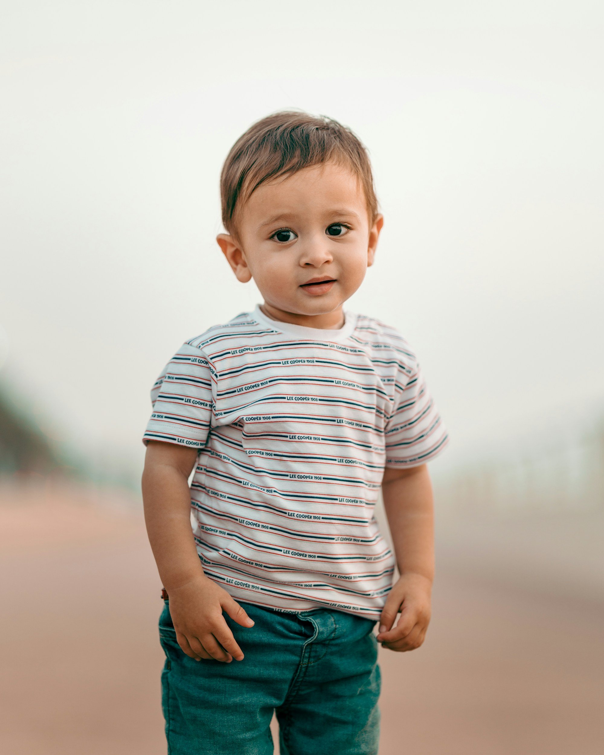 Toddler stands looking at camera.