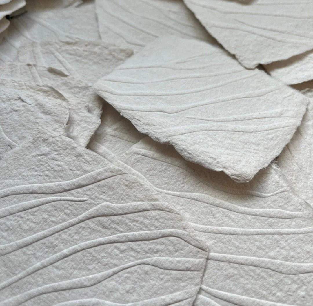 Papier June close-up of textured embossed wavy lines and layered pieces on top.