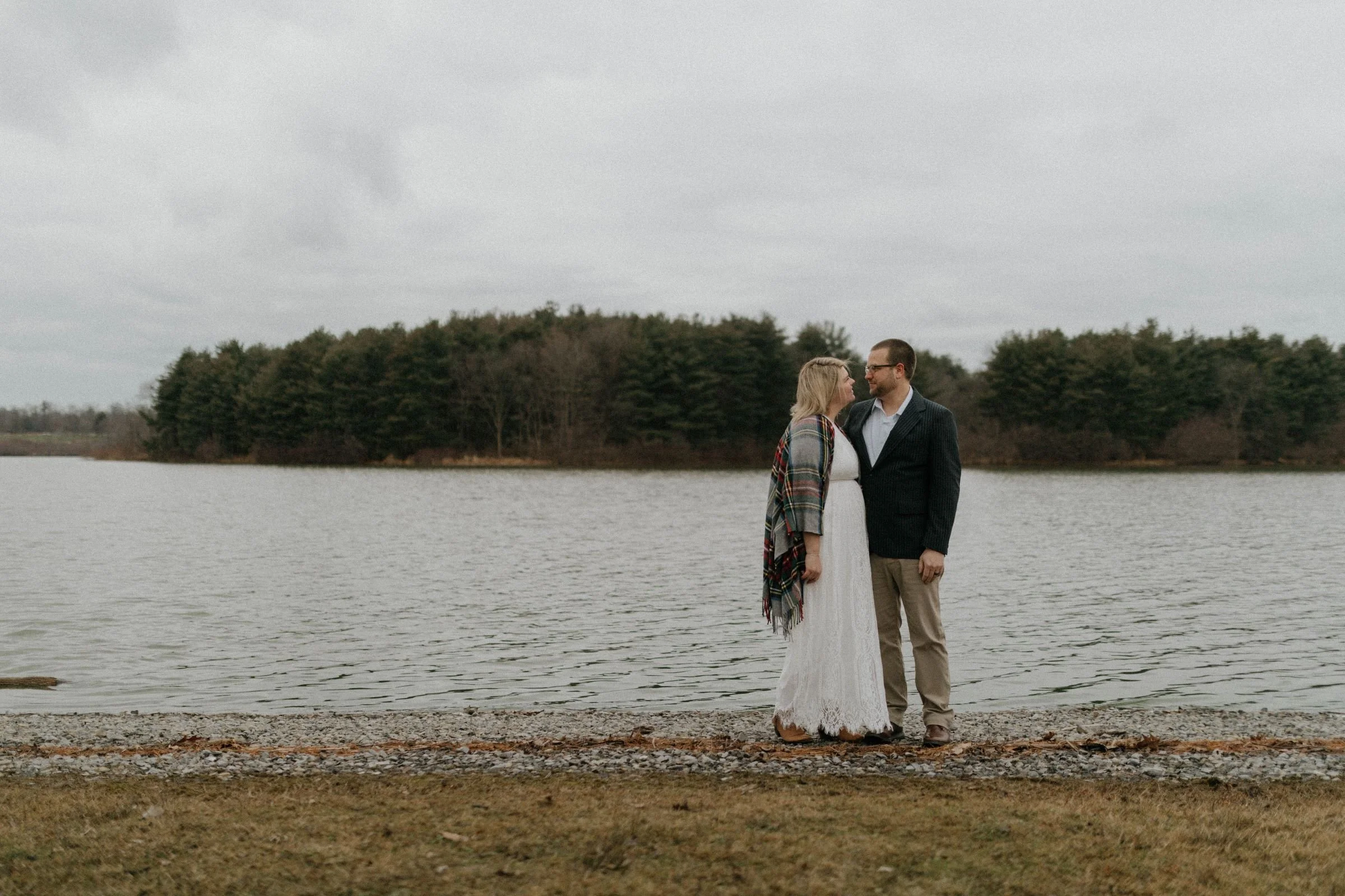 elopement bride and groom gazing at one another while standing on a rocky shoreline in Pennsylvania