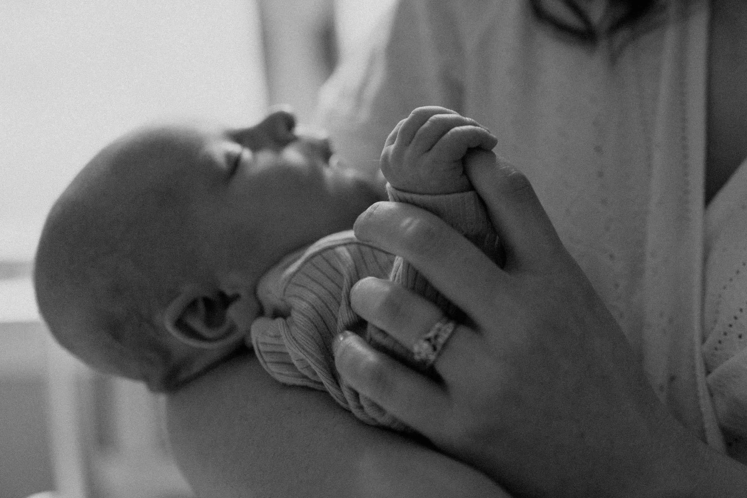 Baby clutching mother's index  finger