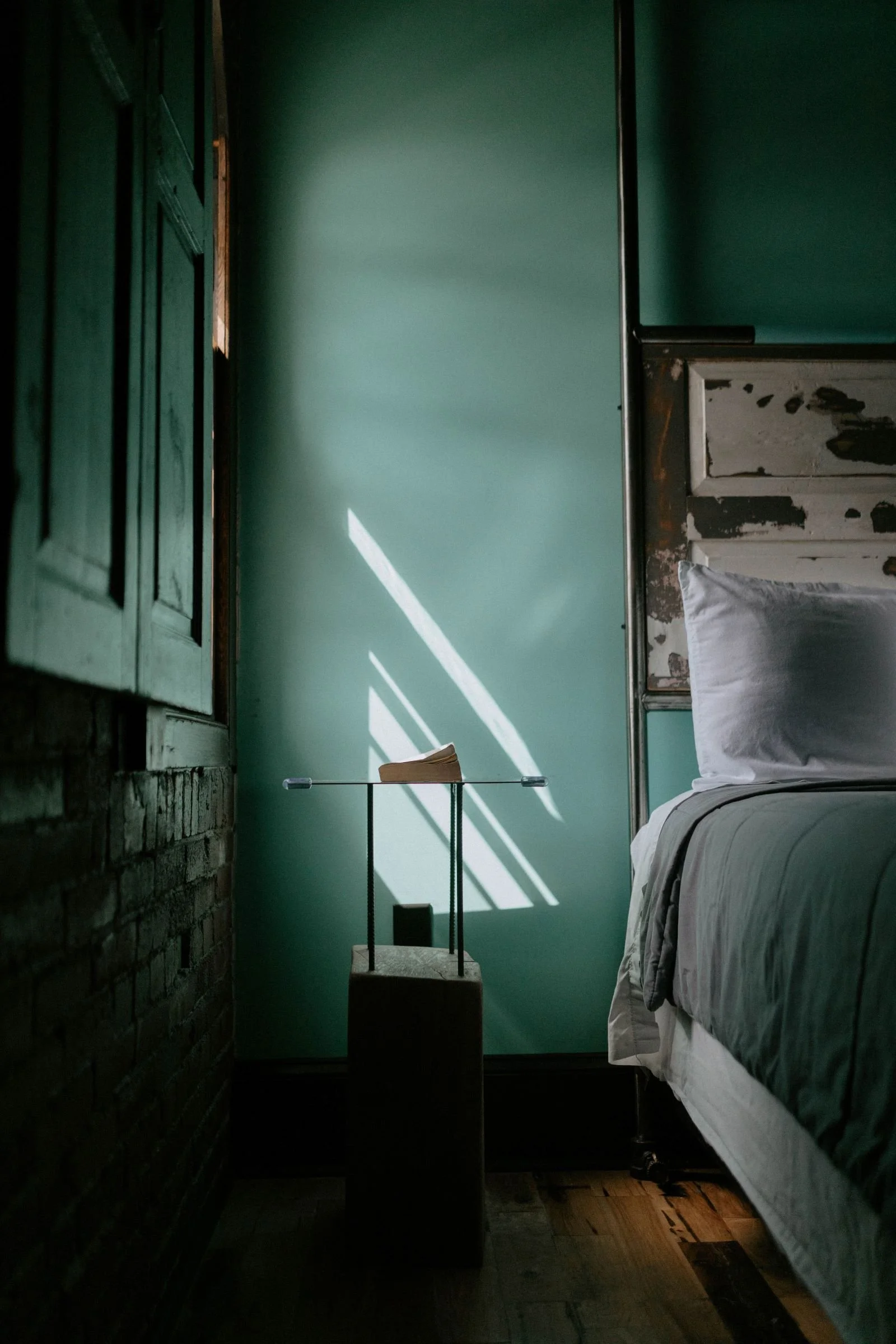 A boutique hotel room with light reflecting on the wall located at City Hall Grand Hotel in WIlliamsport, Pennsylvania.