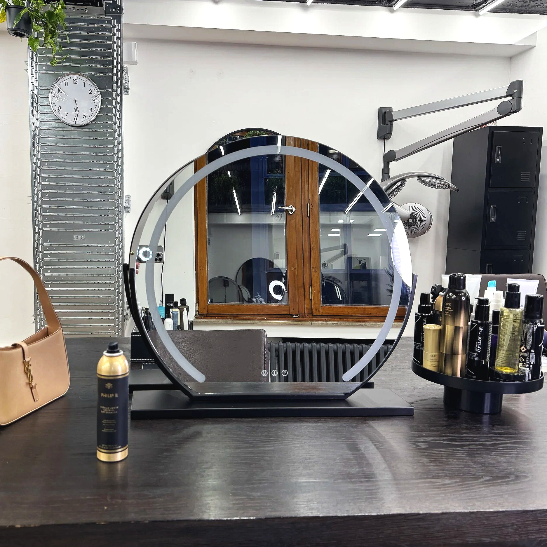 Großzügiger Stylingbereich.
Weiter Arbeitstisch, runder Spiegel und präzise Lichtakzente schaffen eine ruhige, hochwertige Arbeitsumgebung – mit durchdachtem Raum für persönliche Tools und Kundentaschen.