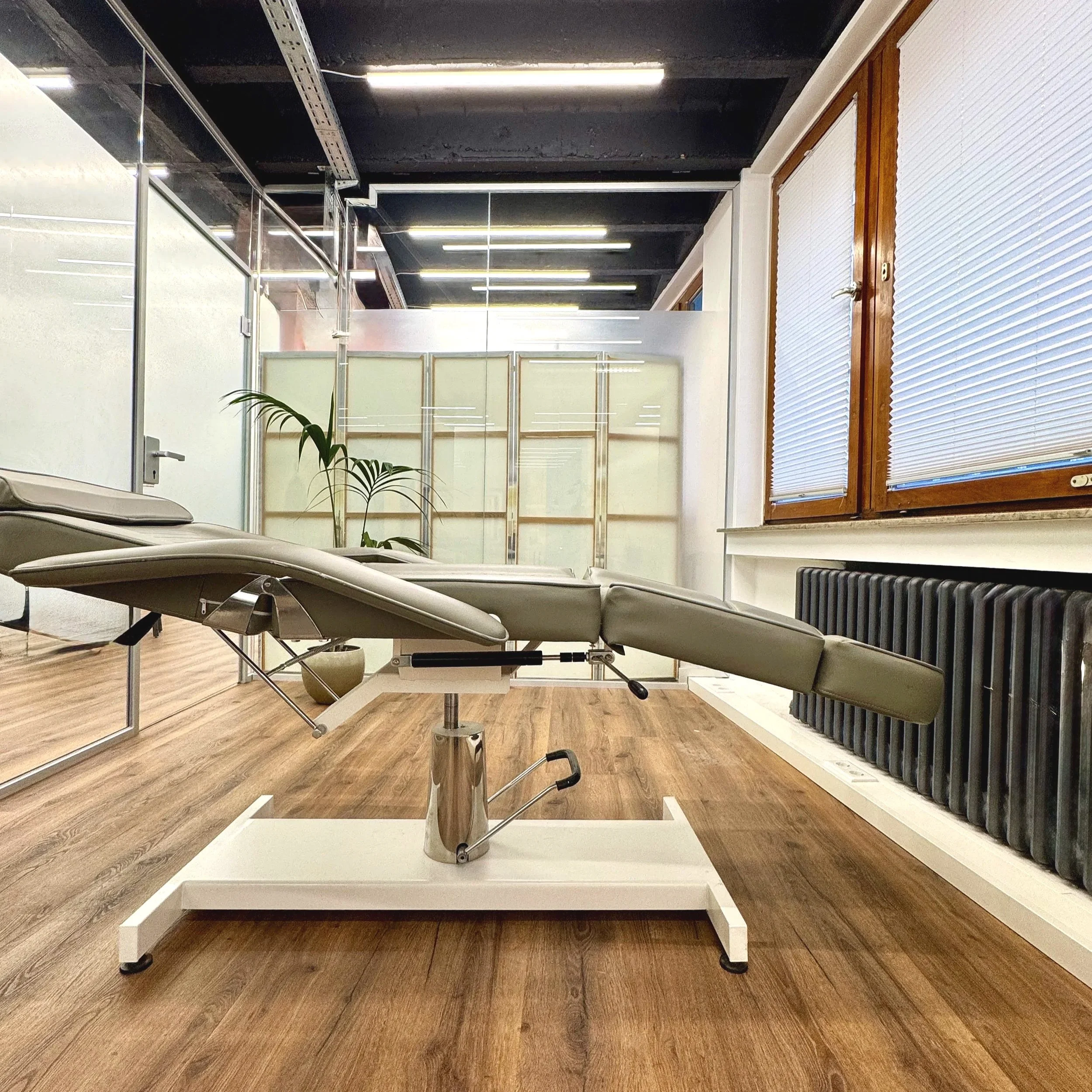 Kosmetik Kabine Komplett aus Glass.
Ein ruhiger Raum für konzentrierte Behandlungen – klar gestaltet und auf präzises Arbeiten ausgerichtet, grosses Fenster, funktionale Liege, warmer Holzboden, grosse Heizung, feine Jalusien in Champagner Farbe.
