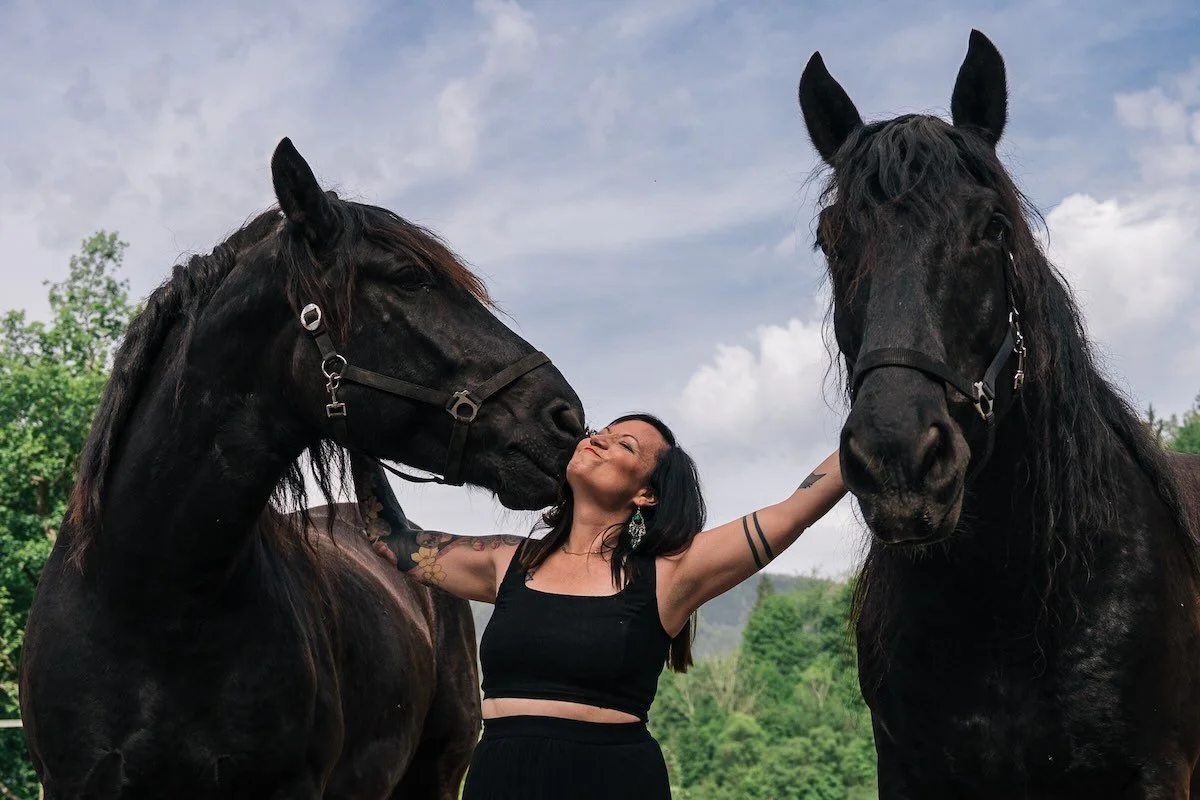 Tierkommunikatorin Alina inmitten von zwei Pferden.