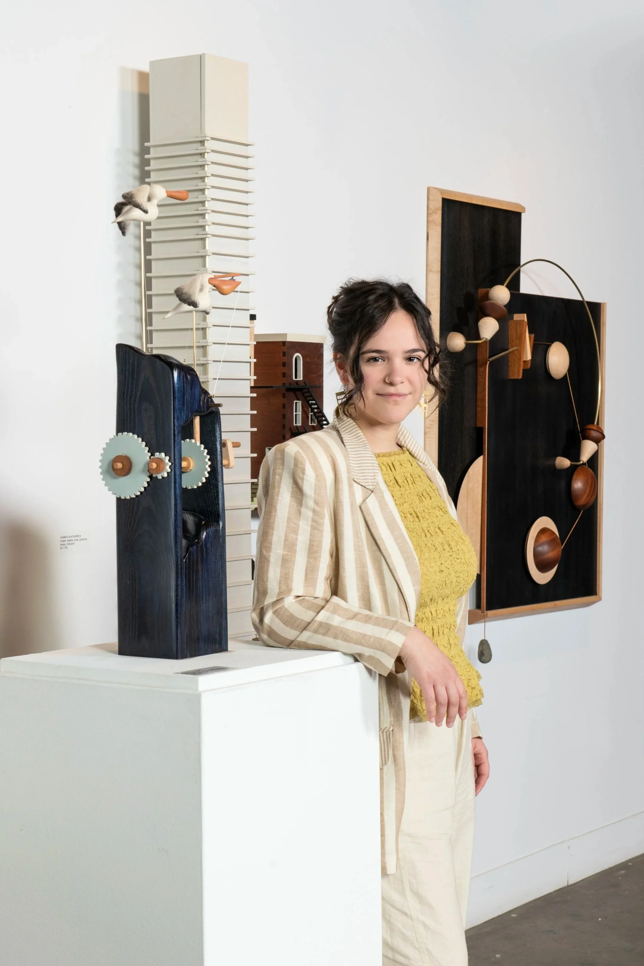 Lin standing in front of her 3 pieces she made for her solo gallery exhibition through the Museum for Art and Wood in partnership with Nextfab.