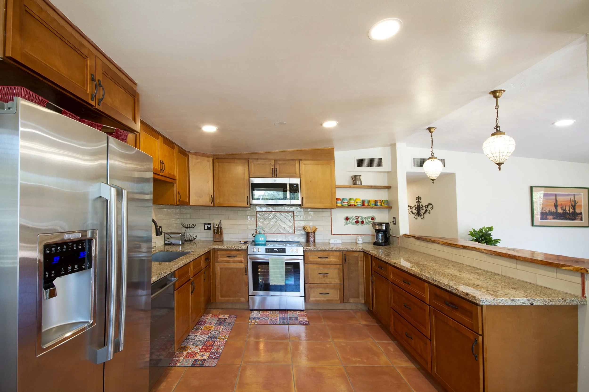 Large kitchen full stocked with cookware and utensils. High quality stainless appliances, including dishwasher and coffee maker (with coffee).