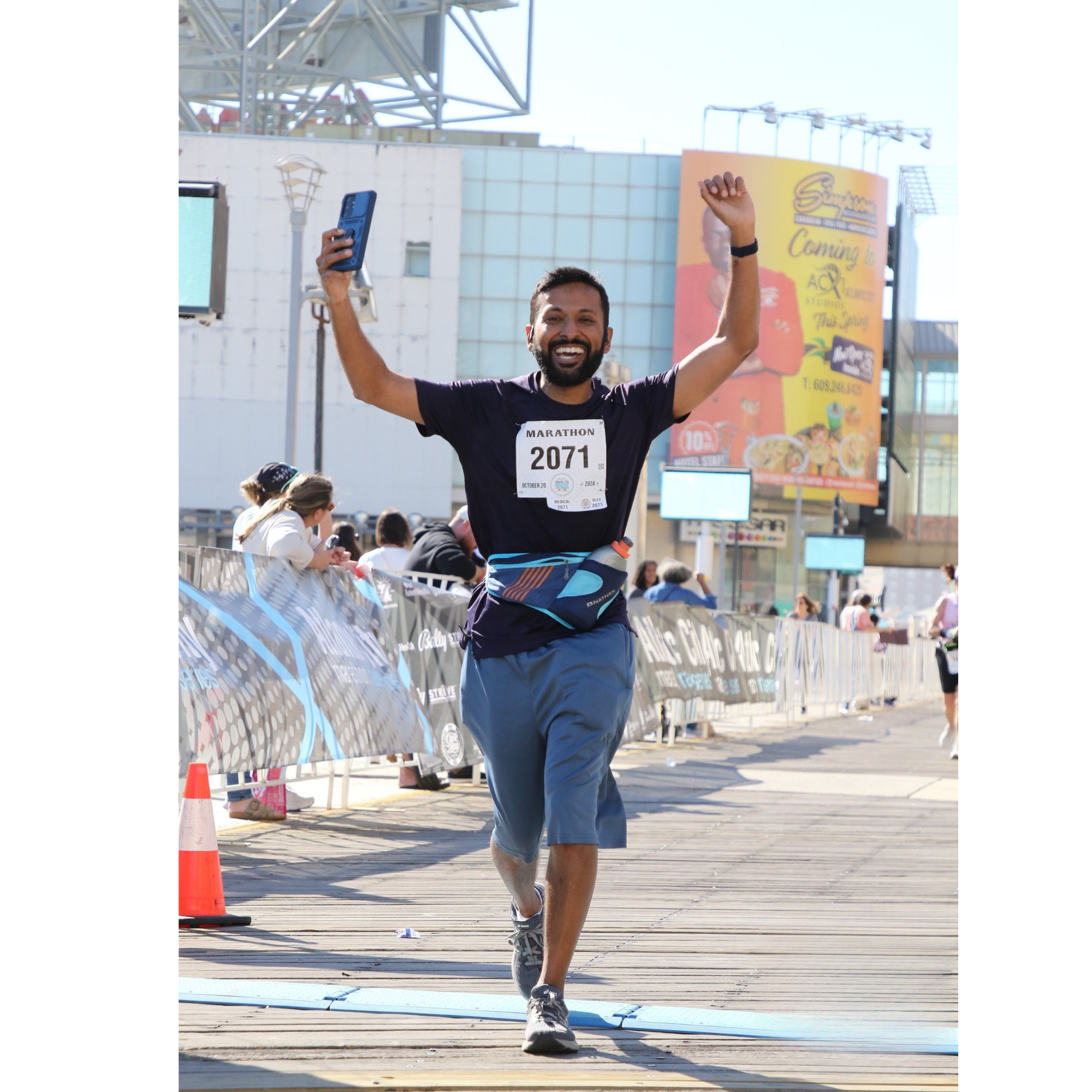 Dr. Mukarram Razvi celebrating as he finishes a marathon