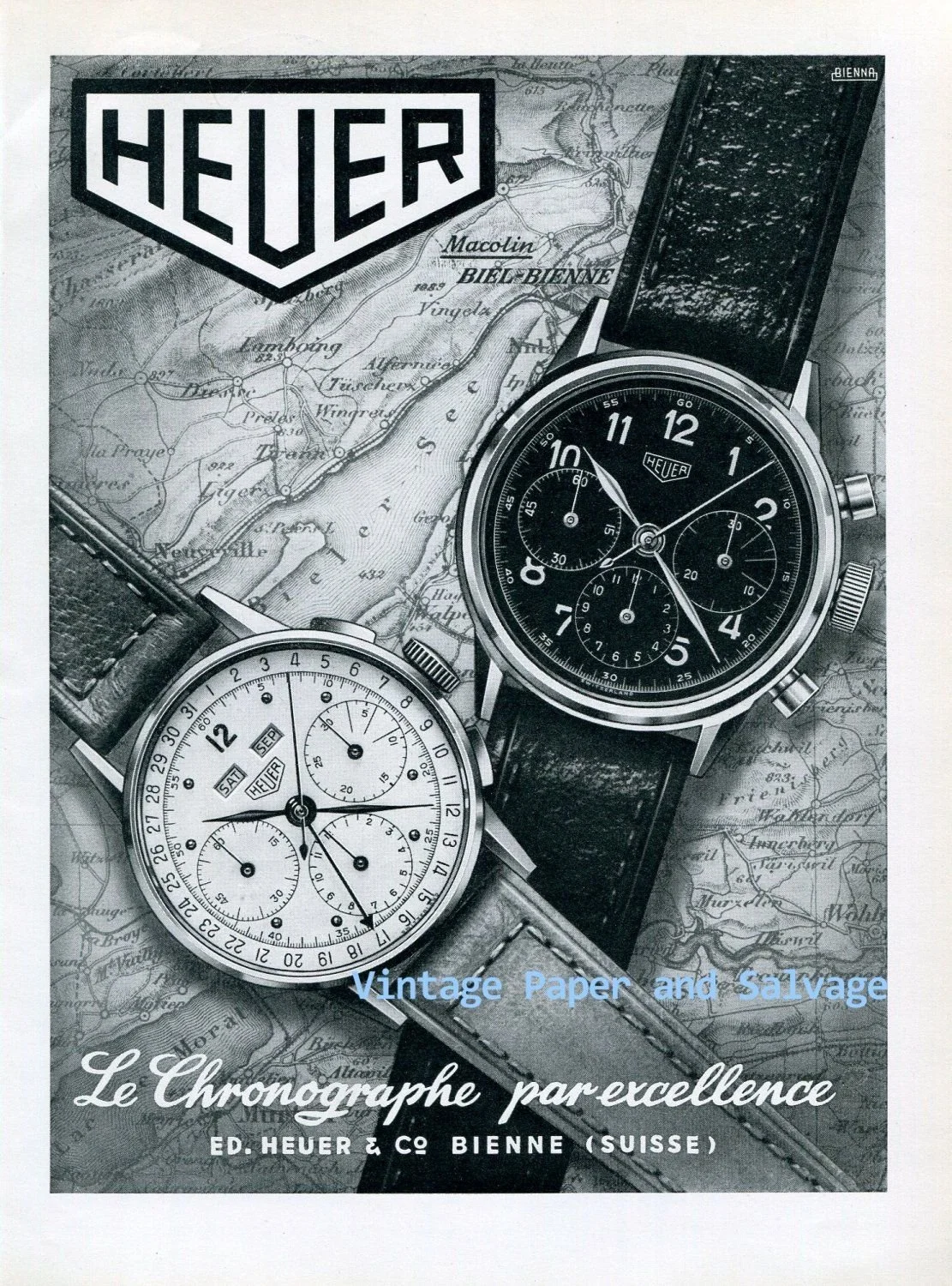 Black and white advertisement featuring two vintage Heuer watches placed over a map of Bienne, Switzerland. One watch has a leather strap, the other a metal band. The text reads 'Vintage Paper and Salvage,' 'Le Chronographe par excellence,' and 'ED. HEUER & Co Bienne (Suisse).'