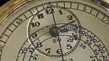 Close-up of a vintage stopwatch with multiple dials and markings.