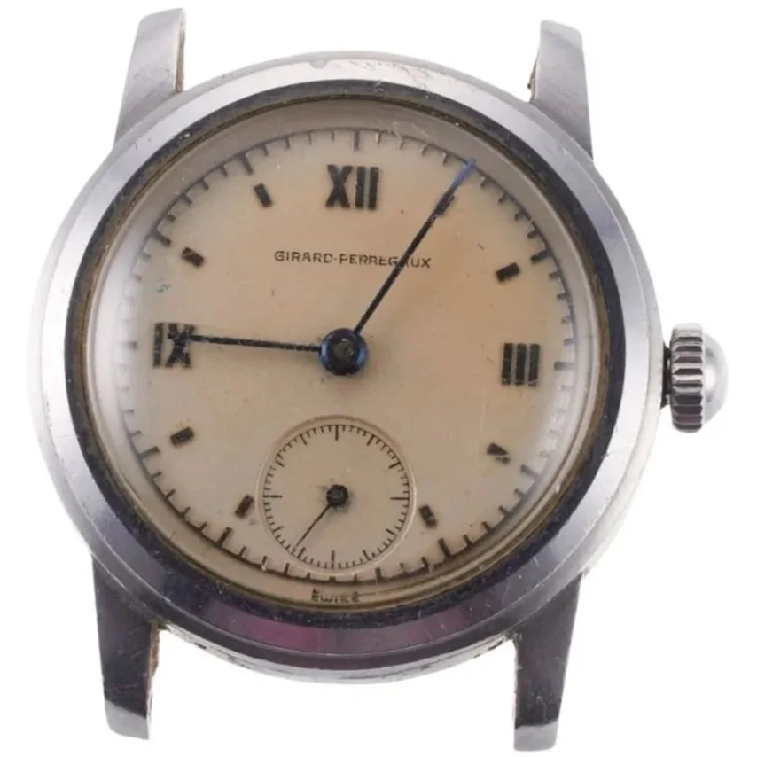 Vintage Girard-Perregaux wristwatch with a beige dial showing Roman numerals, a small seconds subdial at the 6 o'clock position, and black hands, with the time approximately 9:07.