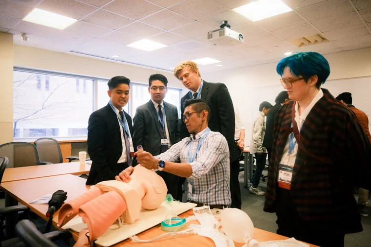 Trainees practice a clinical skill on simulation models during a workshop.