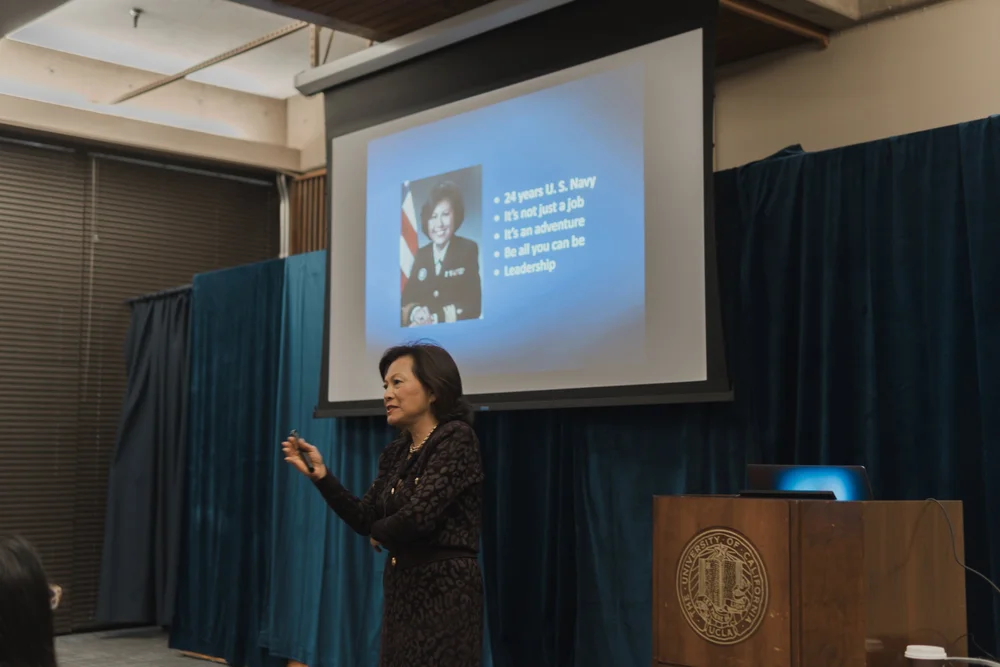 A keynote speaker presents in front of a projected slide
