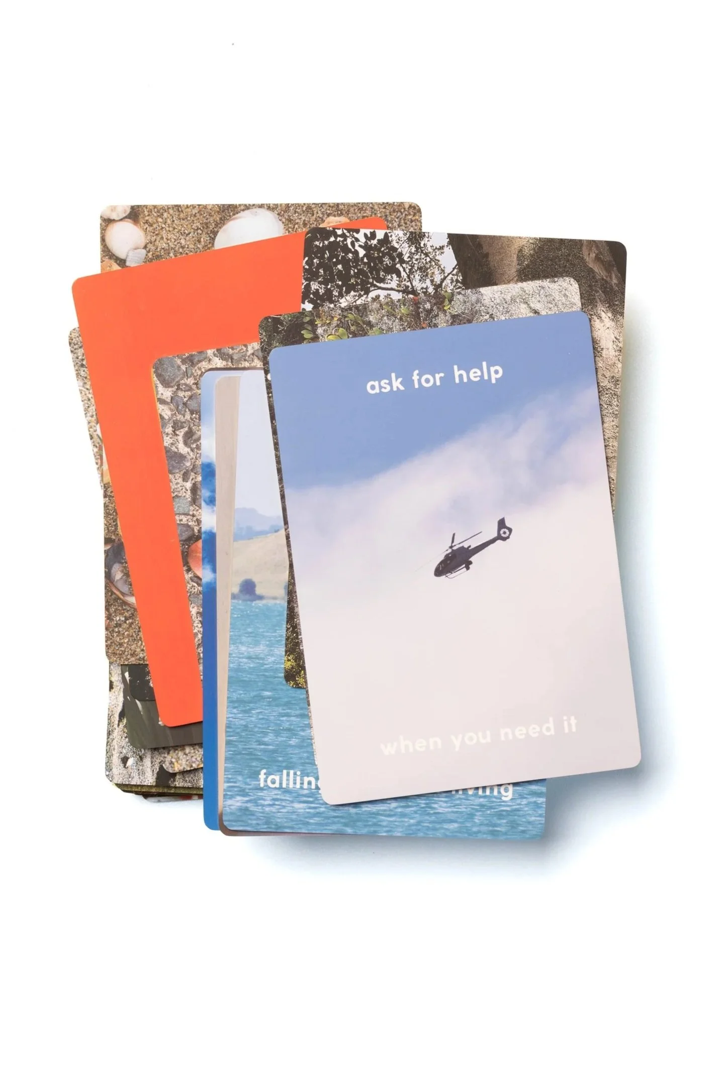 Collection of colorful cards with nature and scenic images, including a helicopter and ocean scenes, with messages like "ask for help" and "when you need it".