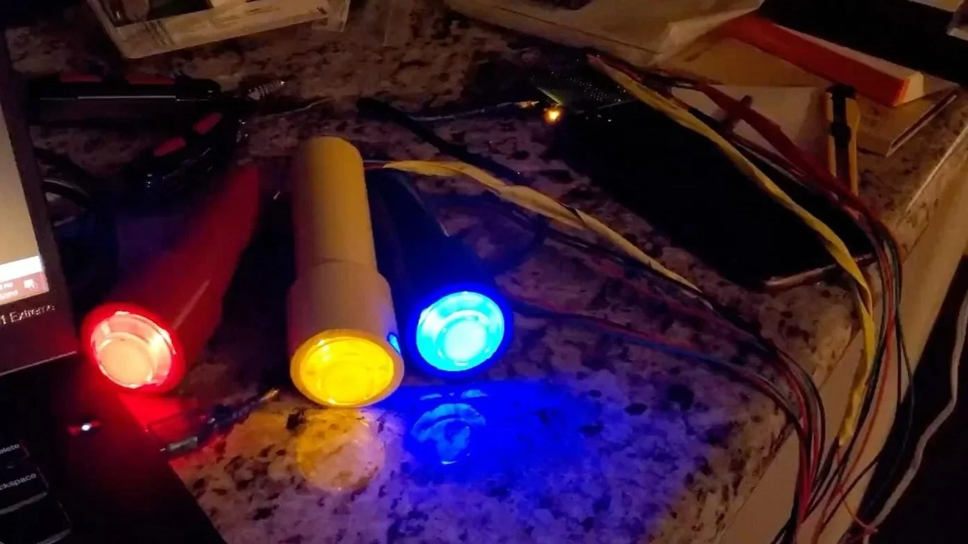 All three handheld signaling devices with a glowing button lit a different color for each of them.