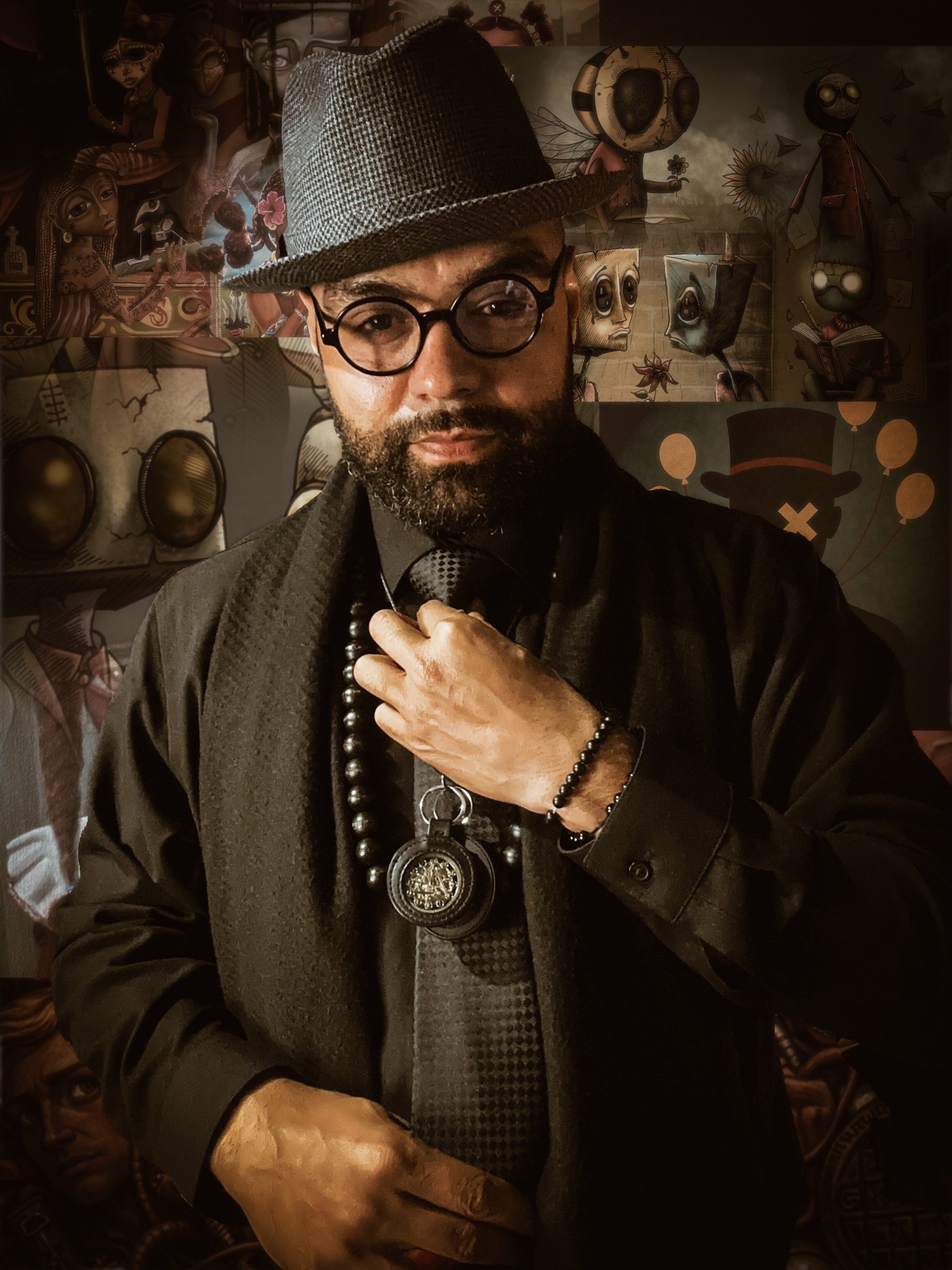 A man with a beard and glasses wearing a gray fedora hat, black shirt, black jacket, and multiple beaded necklaces, standing in front of a backdrop with various stylized and artistic human faces and characters.