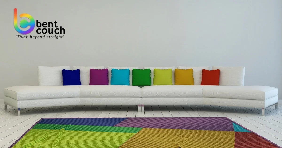 A modern white couch with rainbow coloured cushions and a vibrant rug, representing an inclusive counselling space and challenging common myths about therapy for gay men seeking support.