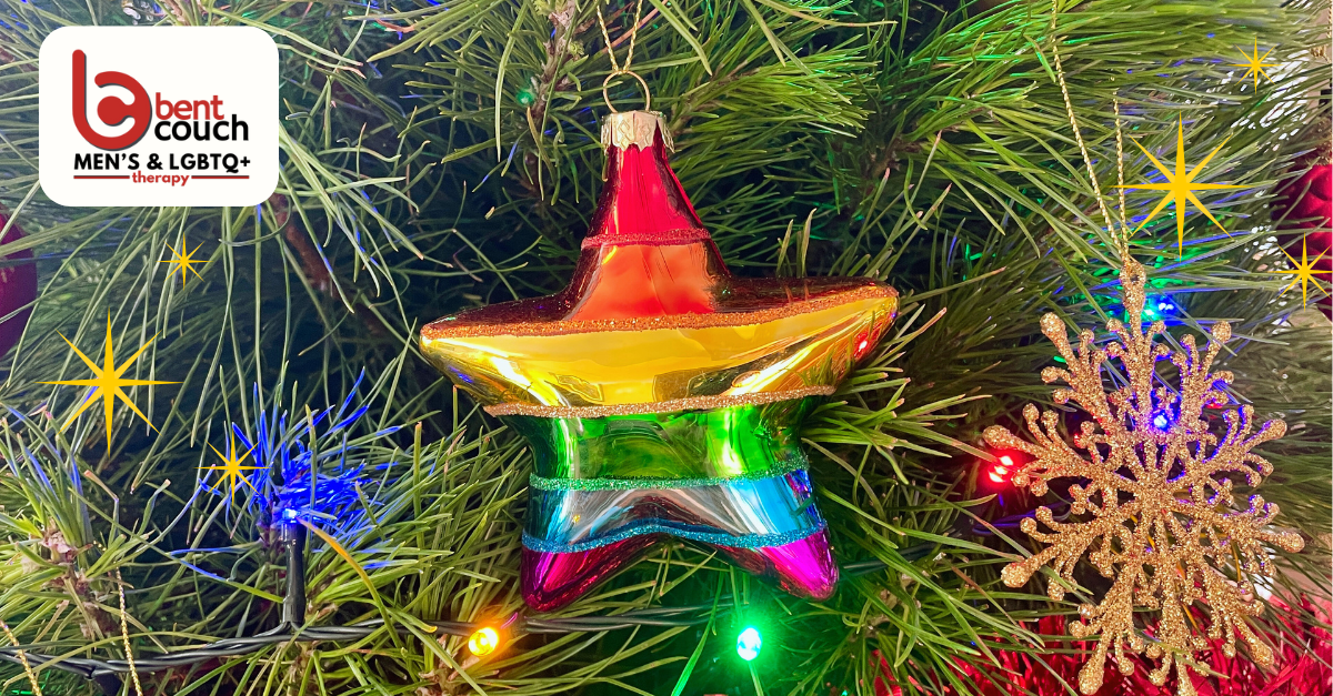 A rainbow star ornament and gold snowflake hanging on a Christmas tree with colourful lights, symbolising LGBTQ pride and festive wellbeing for the Holiday Survival Guide for LGBTQ mental health.