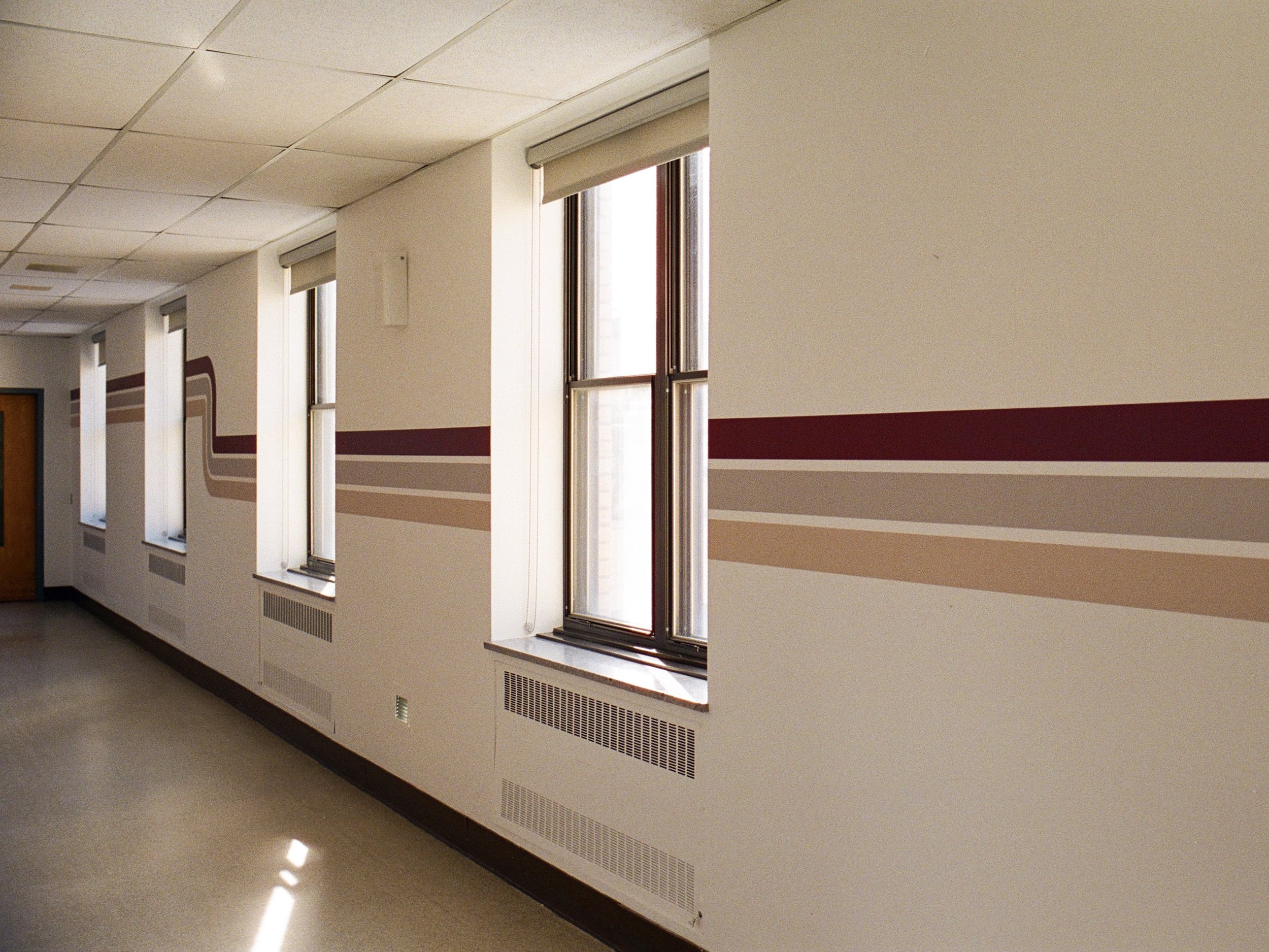 Vue d'ensemble corridor CHSLD avec bandes murales bourgogne et beige