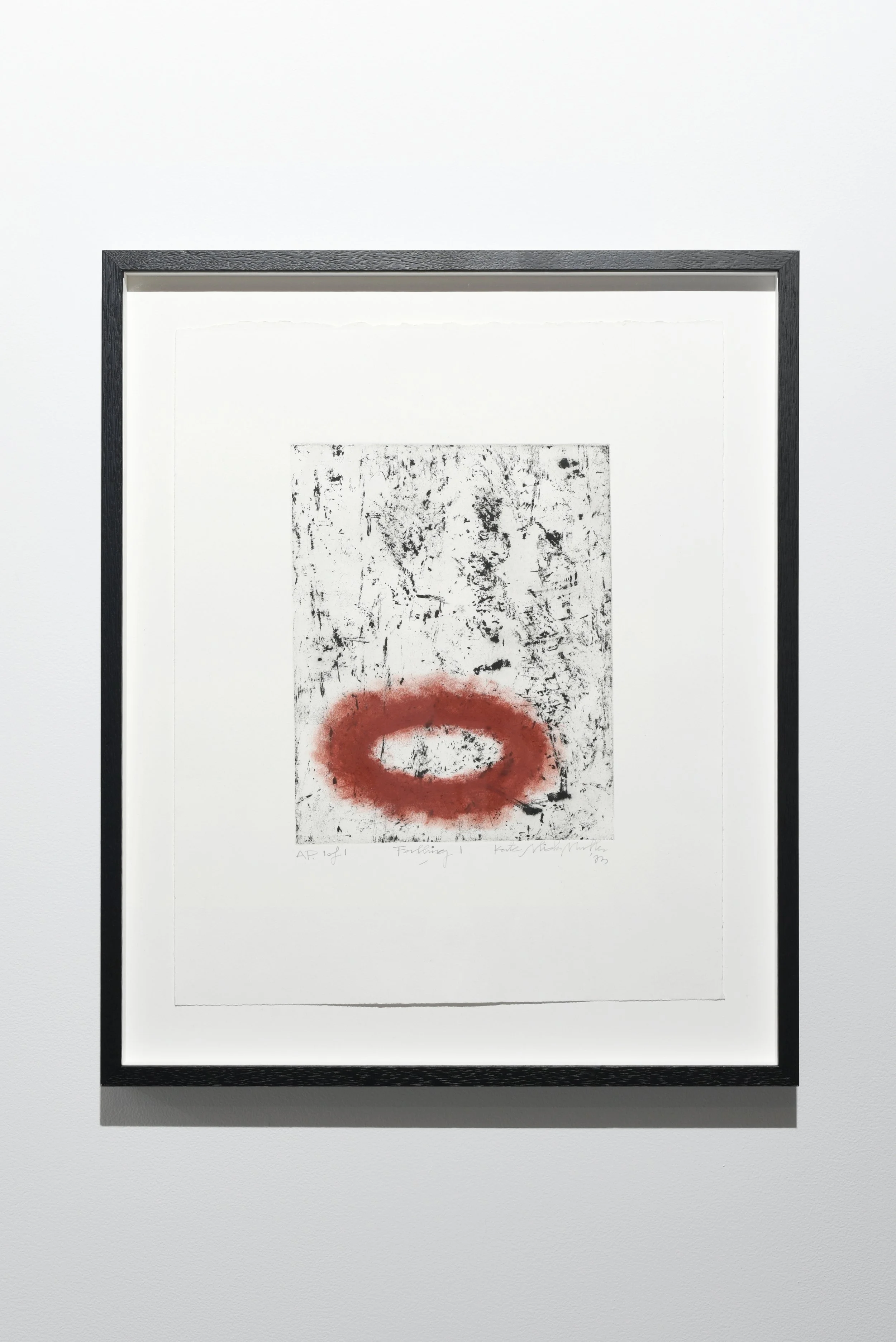 A black-and-white abstract artwork with a red circle in the center, framed and displayed on a white wall. Copyright Kate Alida Mullen