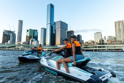 Jetski riders with Brisbane city skyline in background on Moreton Bay