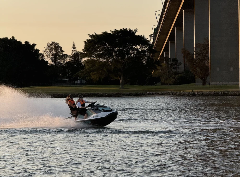 Jetskis cruising past the Brisbane skyline
