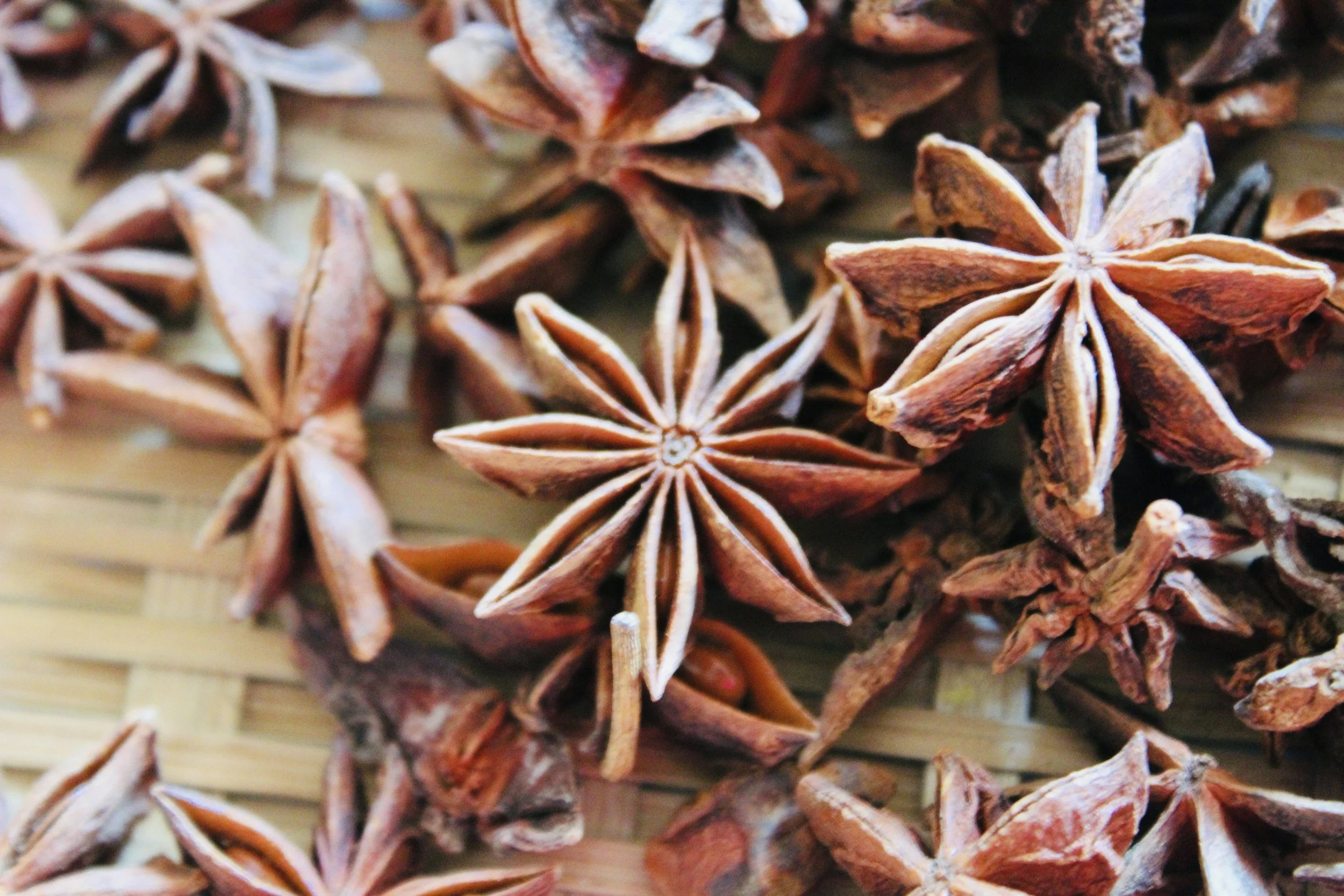Close-up view of star anise spice on woven surface.