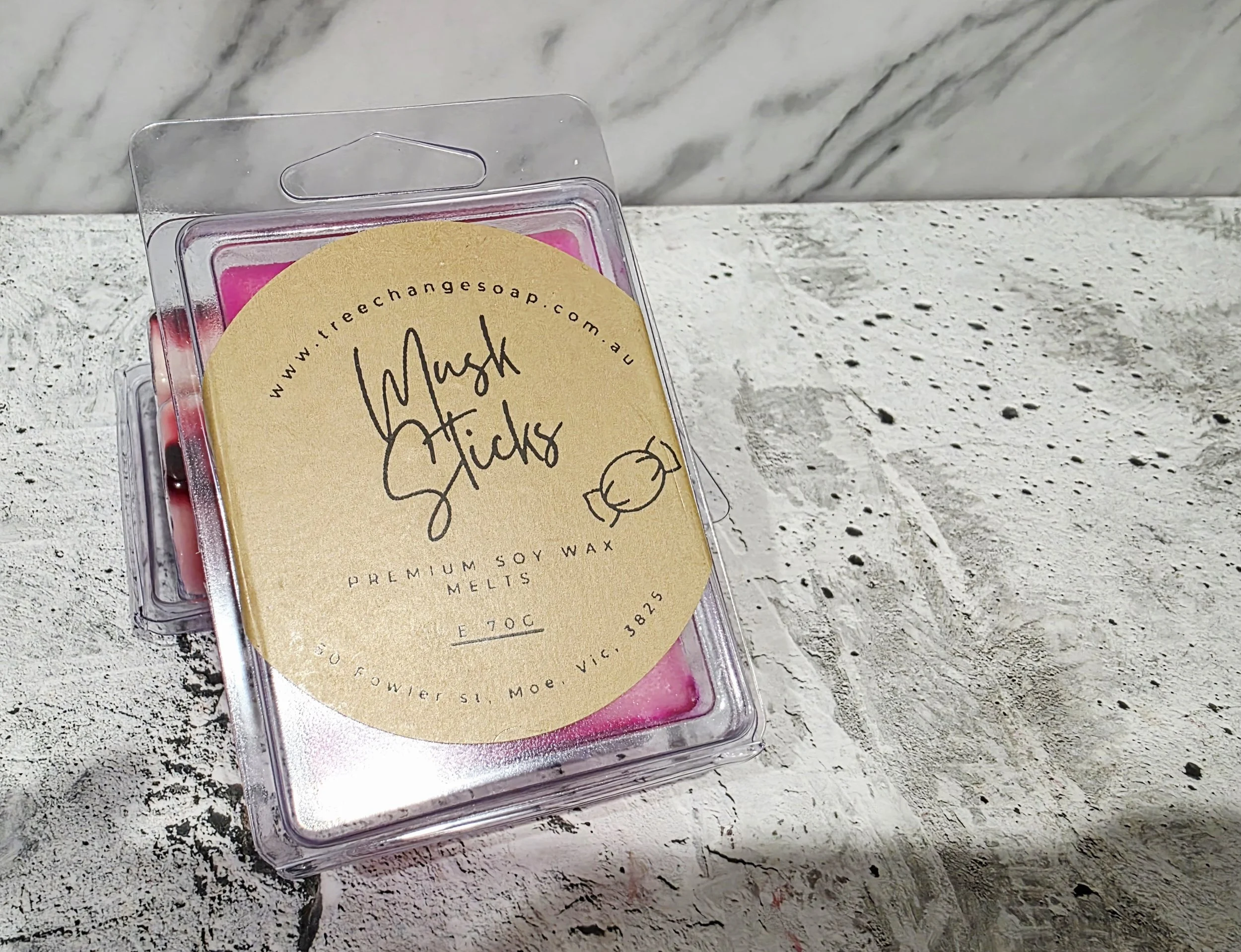 Packaging of wax melts labeled 'Mush Micks' with a website URL, scent description 'E 70C', weight 382 grams, on a textured surface.