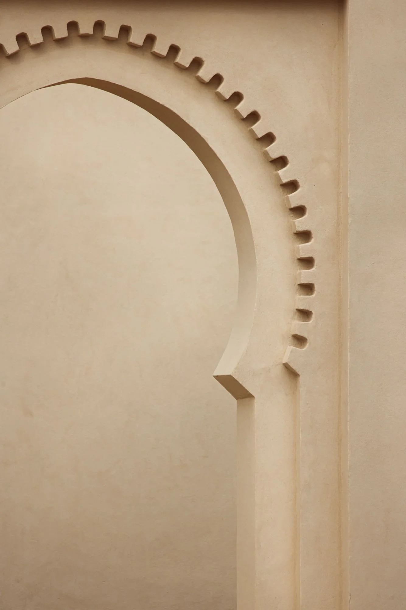A close-up view of a decorative circular pattern with notched edges on a beige wall. Royal Mansour Tamuda Bay Morocco. Photography Sophia van den Hoek
