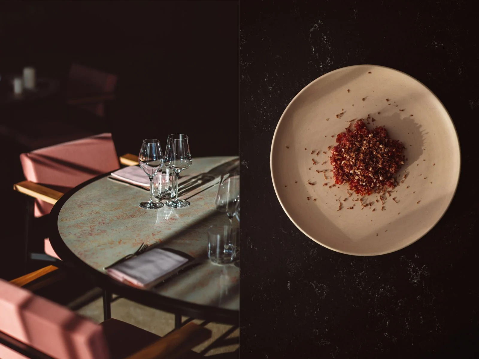 Empty restaurant table set with wine glasses, plates, napkins, and pink chairs, divided by a vertical line. On the right side, a white bowl with a serving of finely chopped red and brown food on a dark surface. Restaurant Putaine, Rotterdam, The Neth