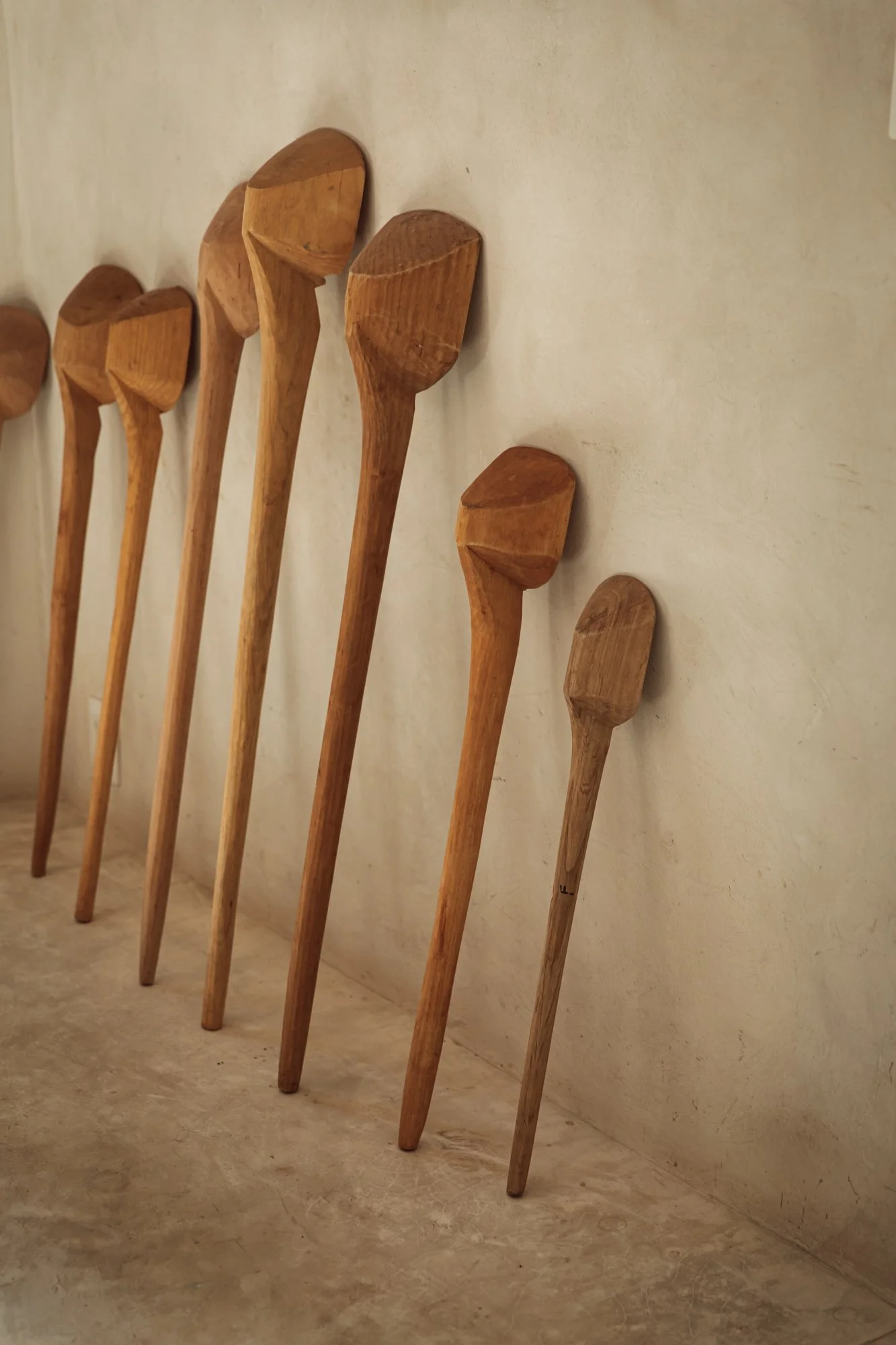 Wooden spoons displayed on textured lime-washed wall at Tulum Treehouse — natural rustic details.