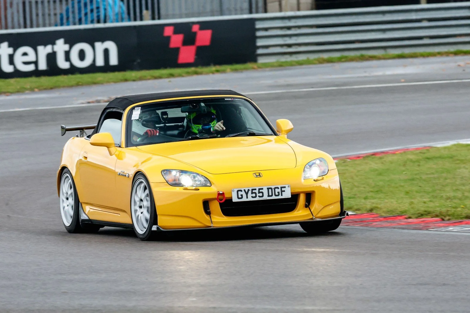Yellow TR imports UK Honda S2000 demonstrator cornering on a wet track at Snetterton.