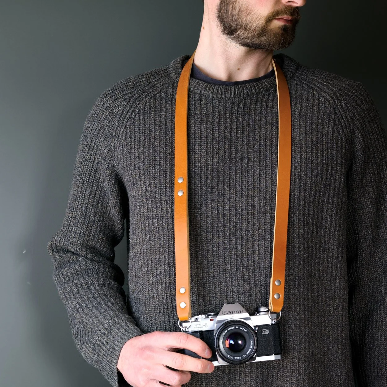Canon leather camera strap worn around neck