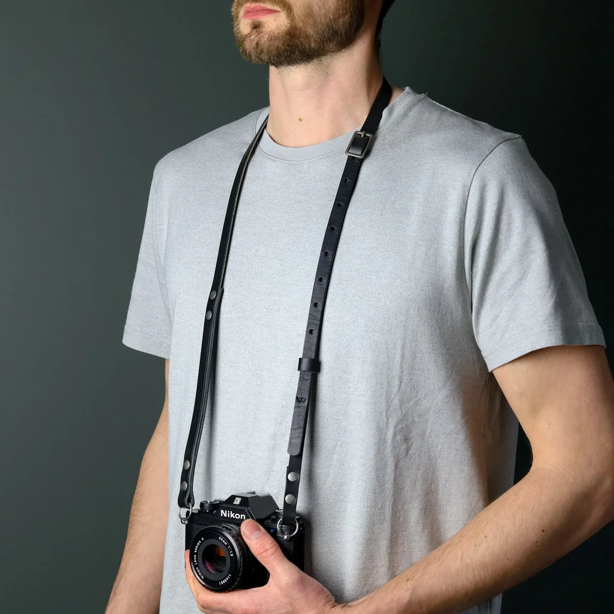 Leather camera neck strap with vintage Nikon camera