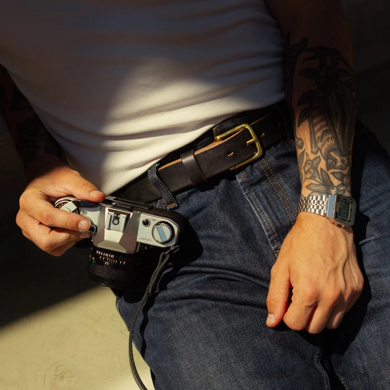 handmade men's leather belt with brass buckle worn with jeans and a white tshirt