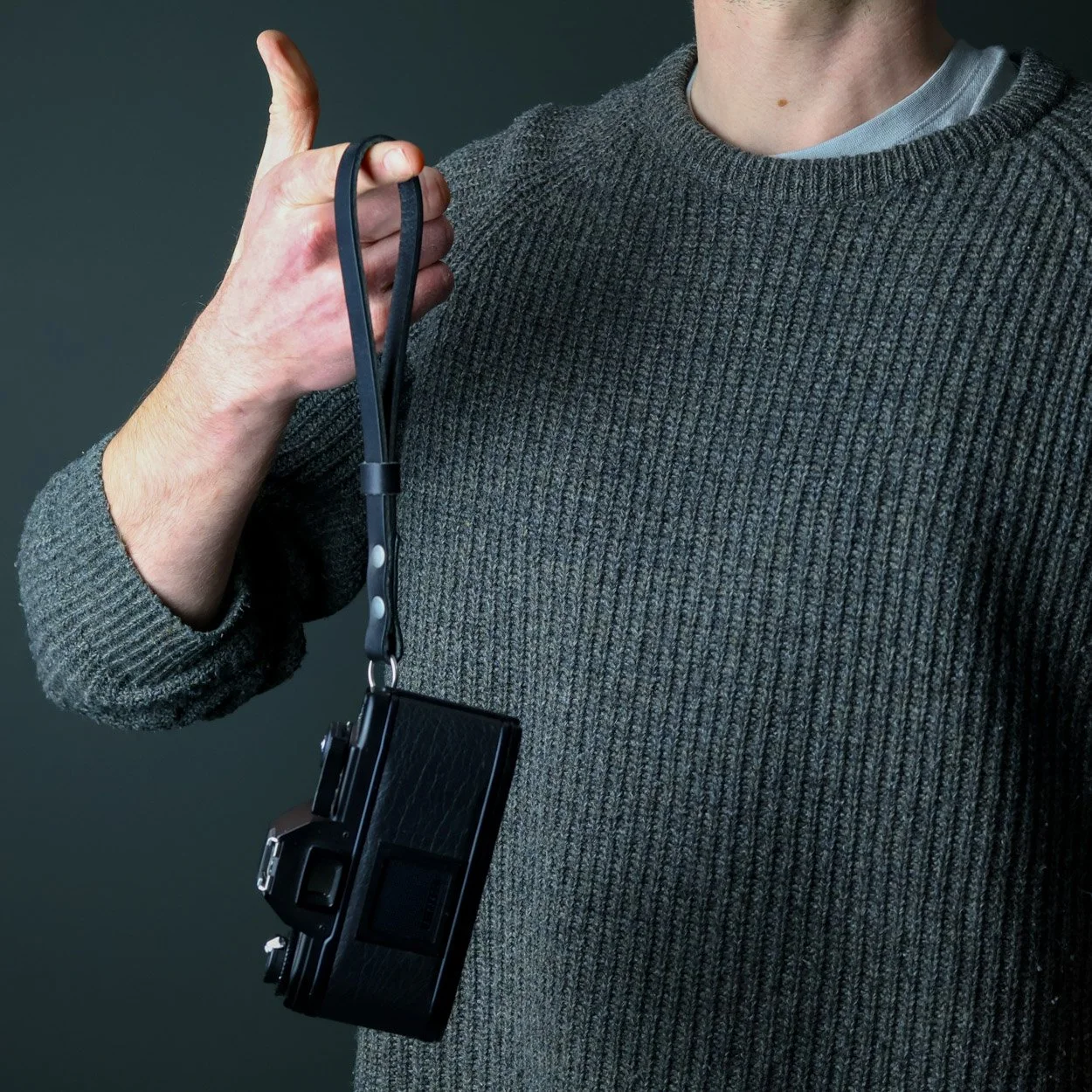 Leather camera wrist strap black dangling on finger made in the UK
